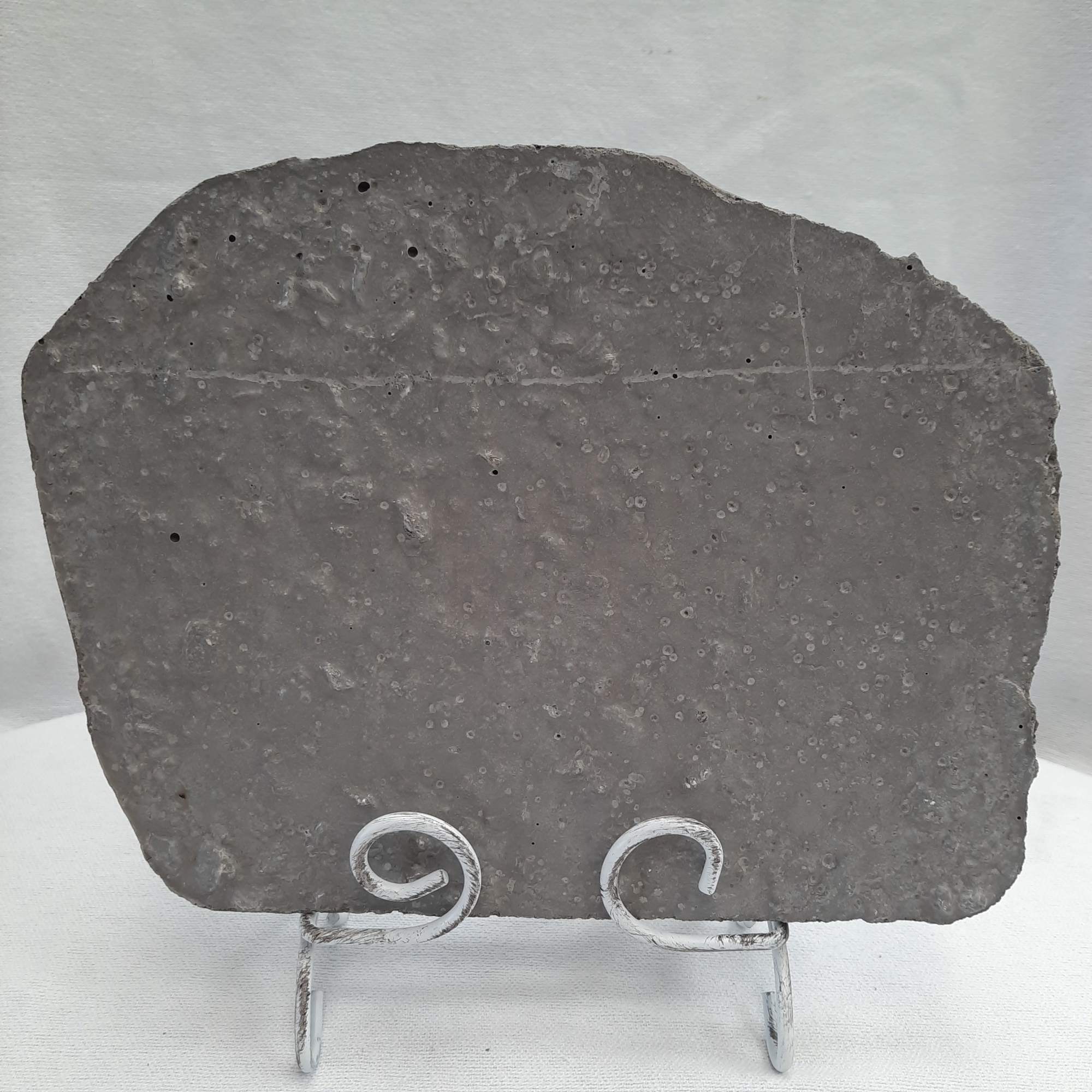 A flat gray stone slab on a small metal stand.