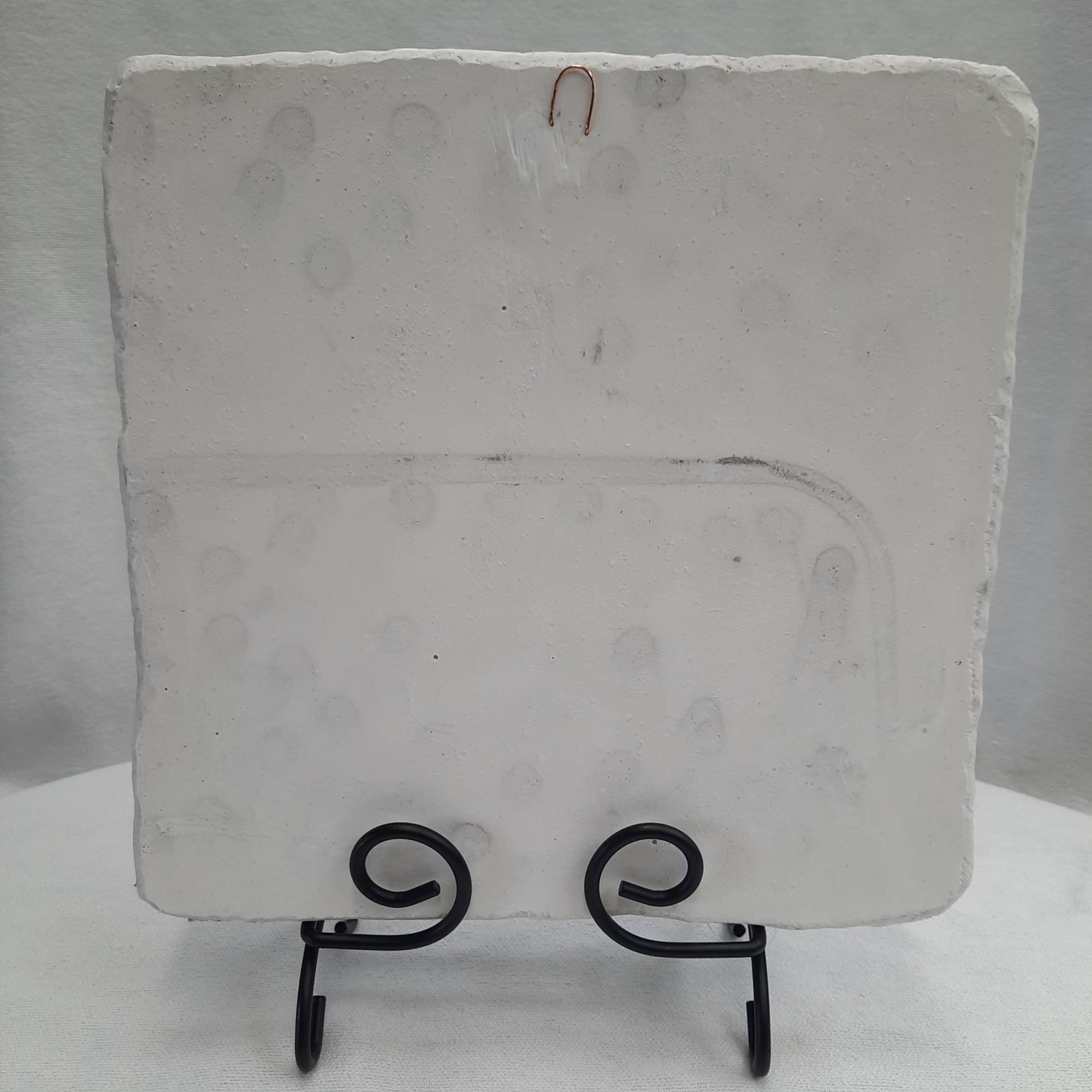 Plain white square plaque on a black display stand