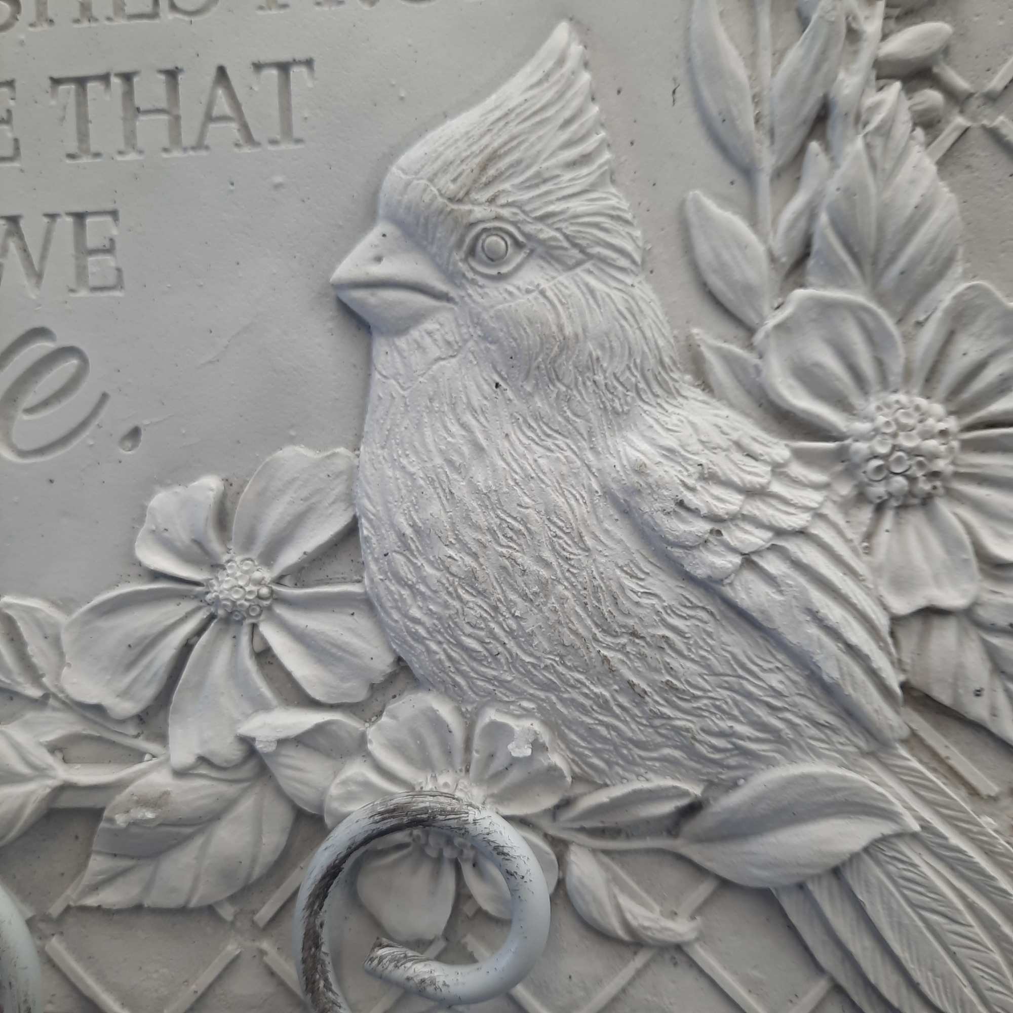 White relief carving of a bird surrounded by flowers and leaves