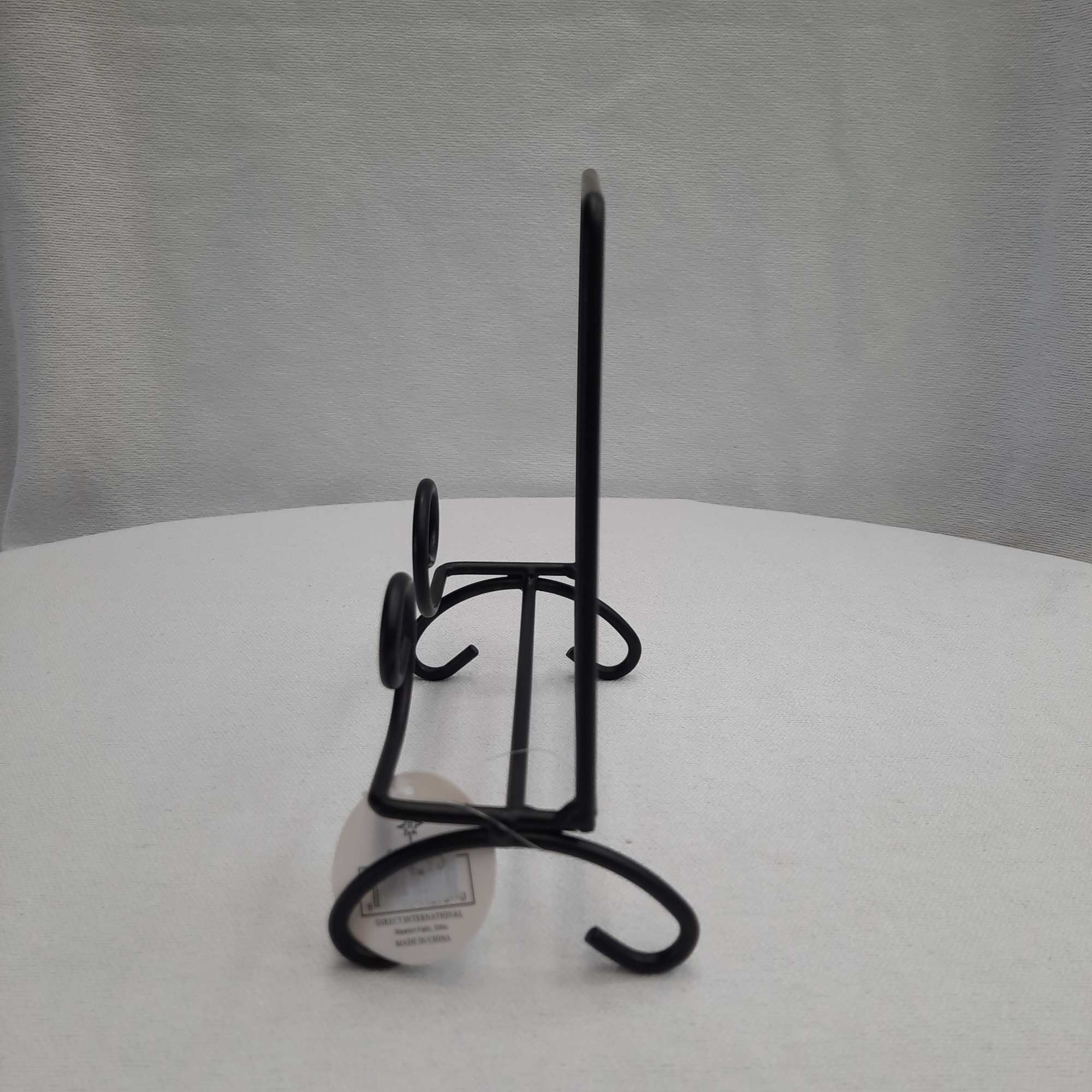 Black metal display stand on a white surface