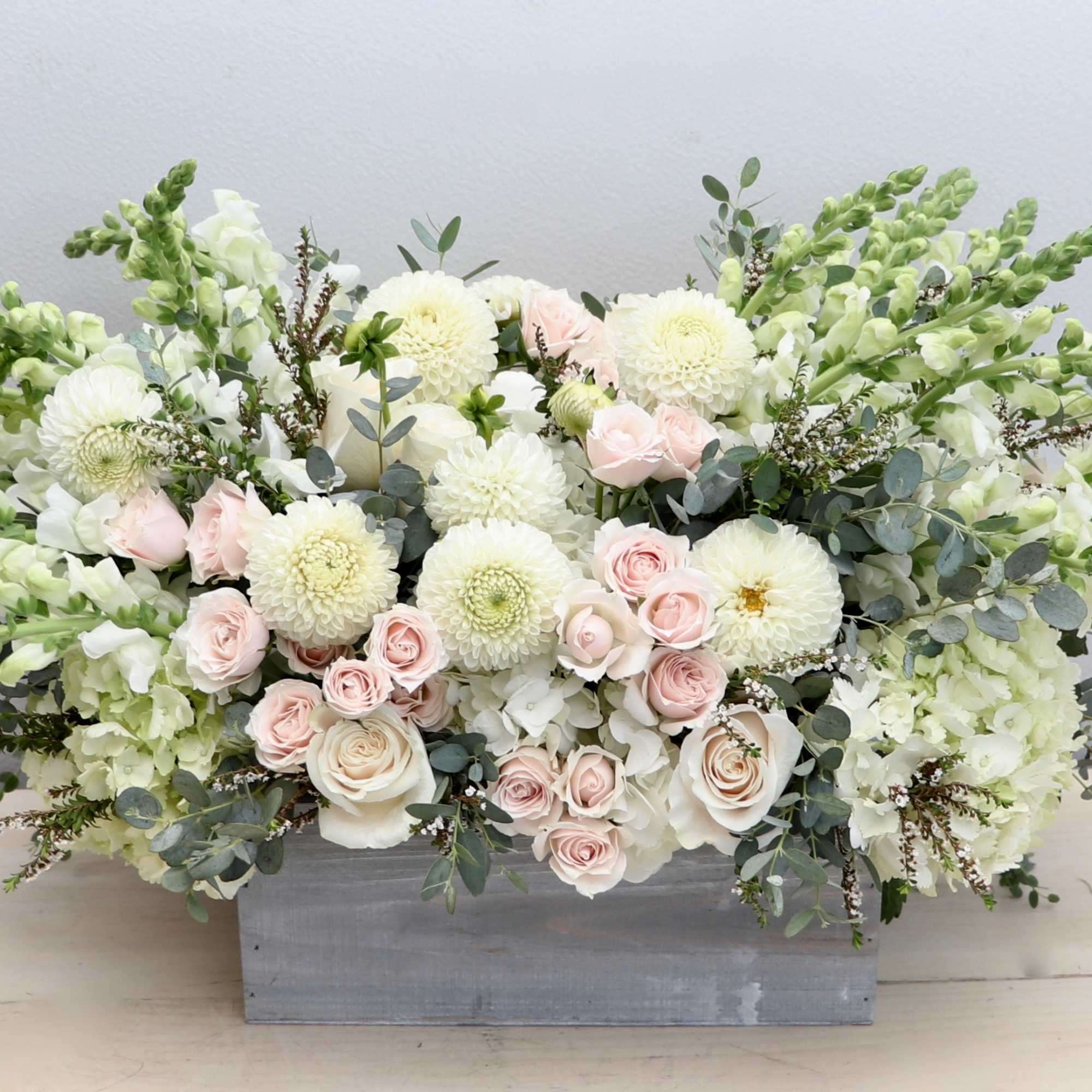 Low white and blush arrangement with roses, dahlias, hydrangeas and snapdragons in a gray wooden box