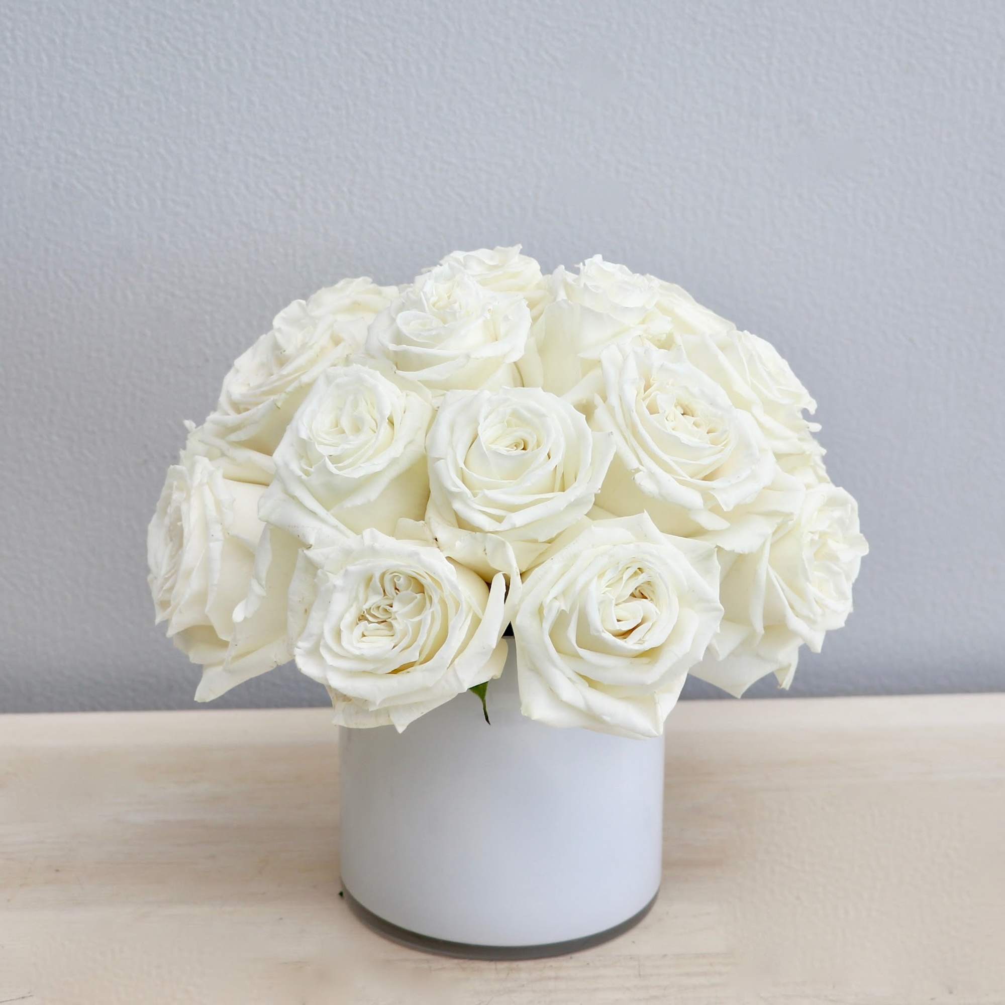 White rose bouquet in a white cylindrical vase