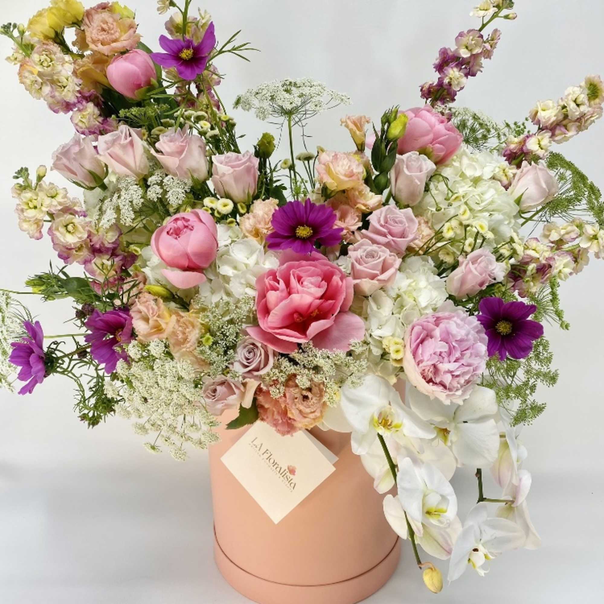 Mixed pink and white flower arrangement in a peach hat box