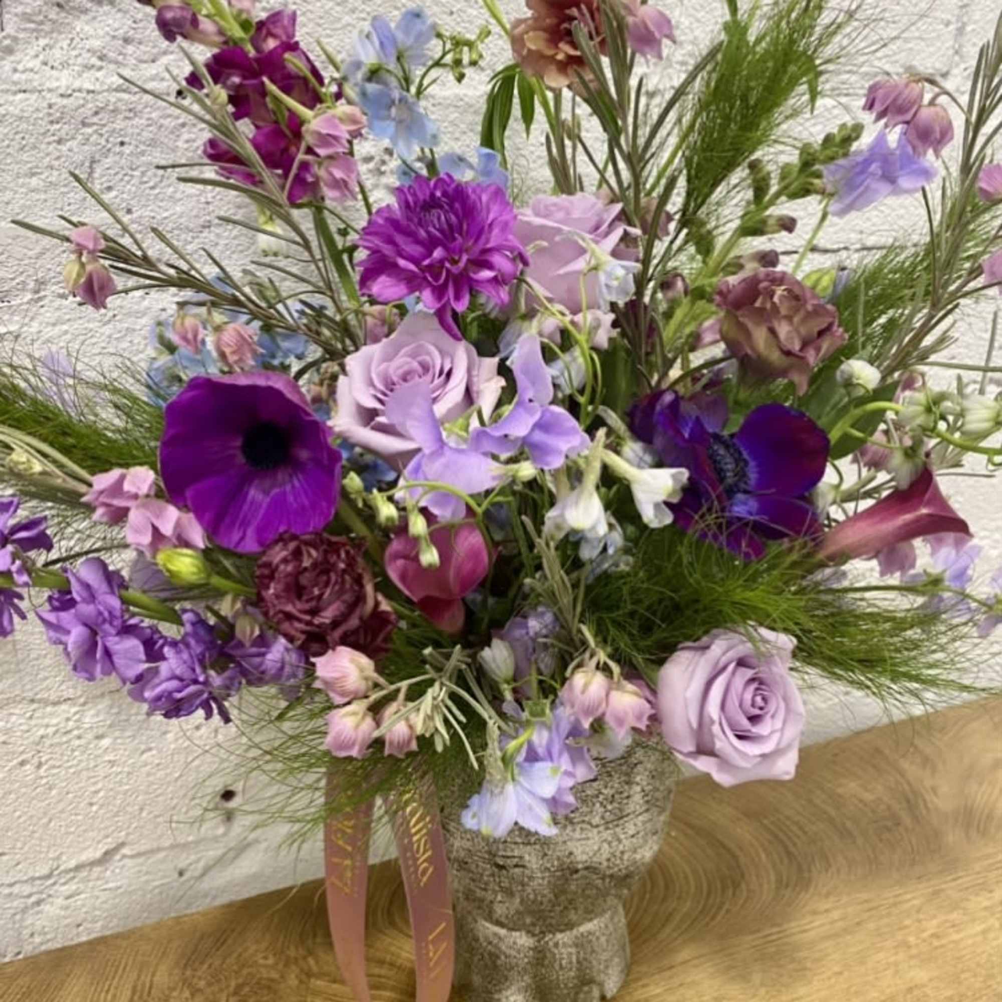 Purple and lavender mixed bouquet in a textured vase