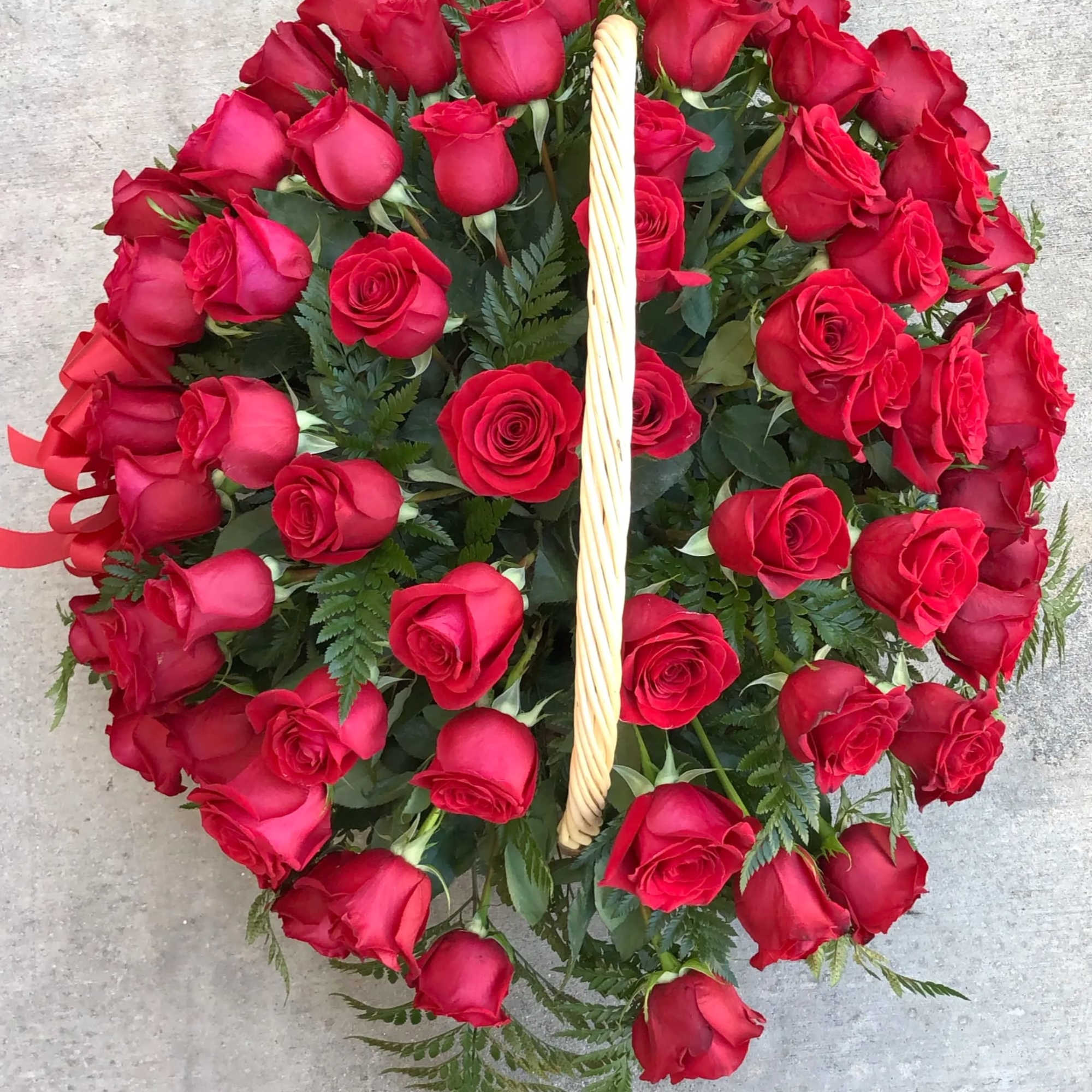 Heart-shaped arrangement of red roses with a woven handle