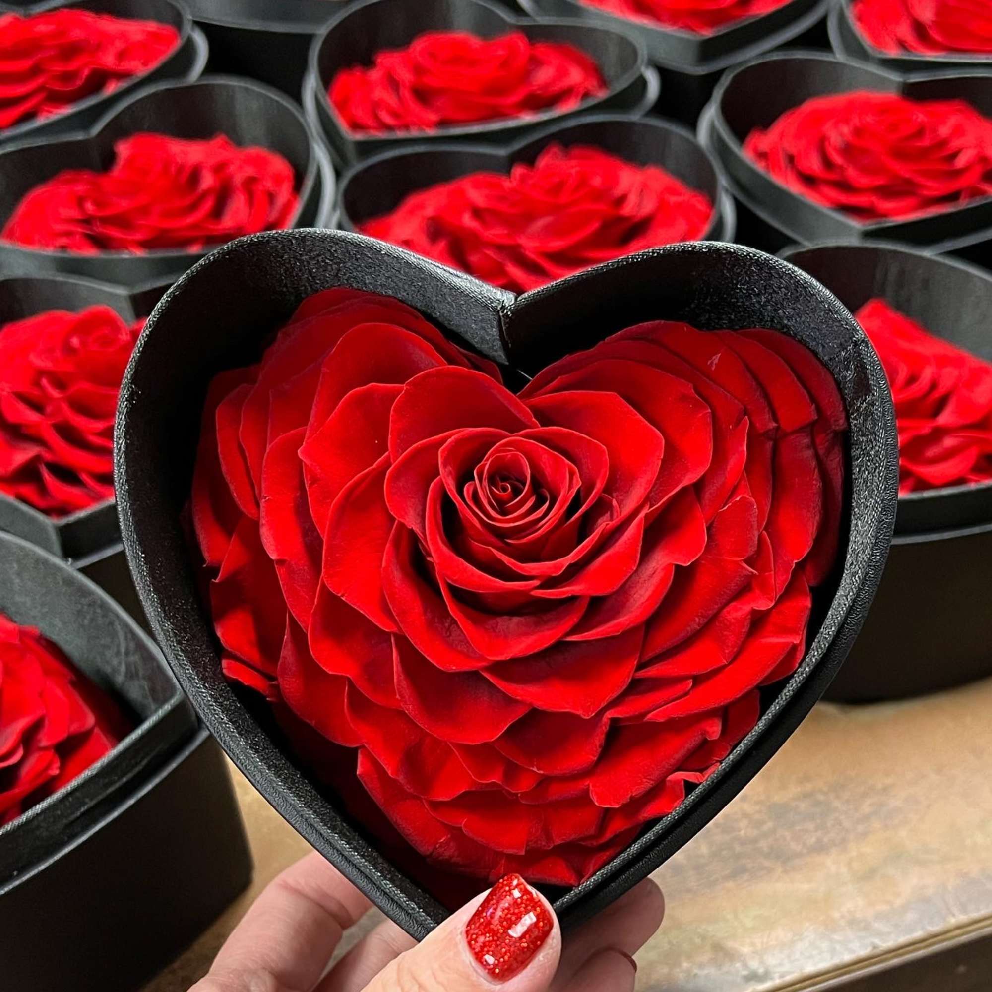 Red rose in a black heart-shaped box