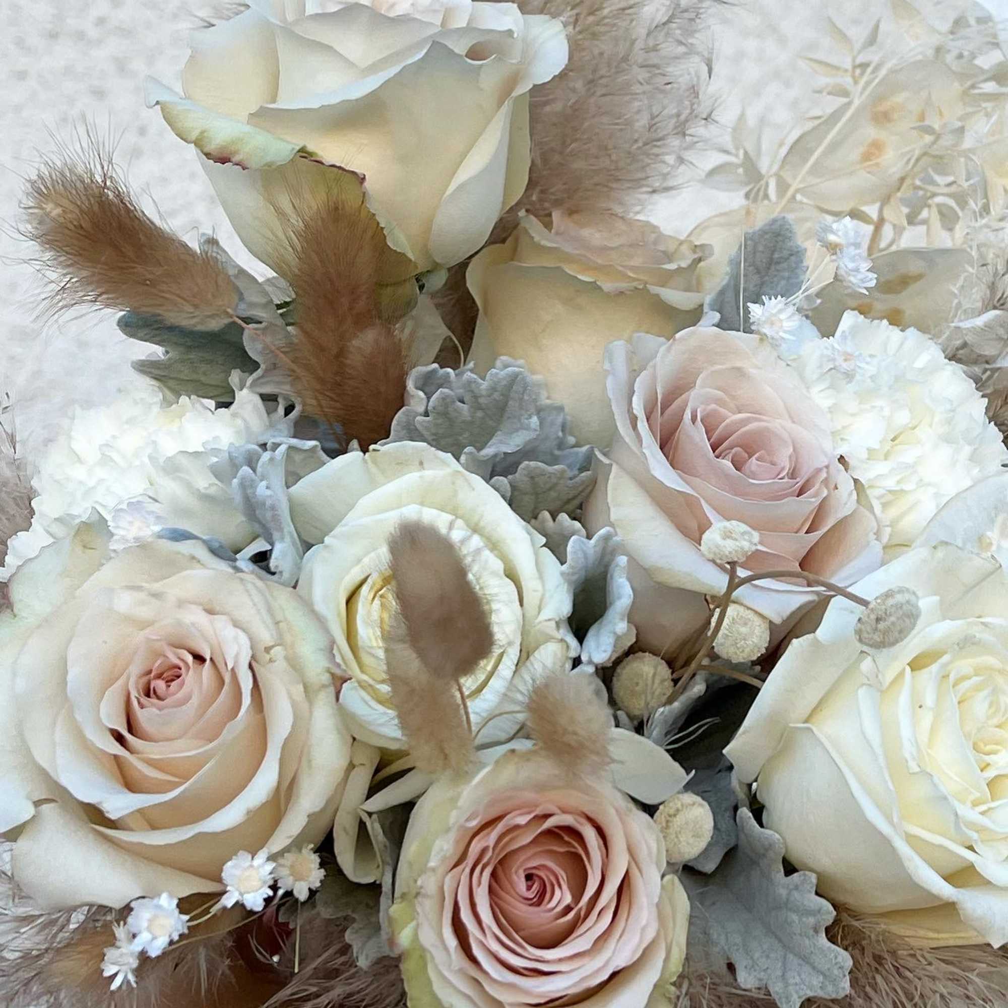 Bouquet of cream and blush roses with dried grasses