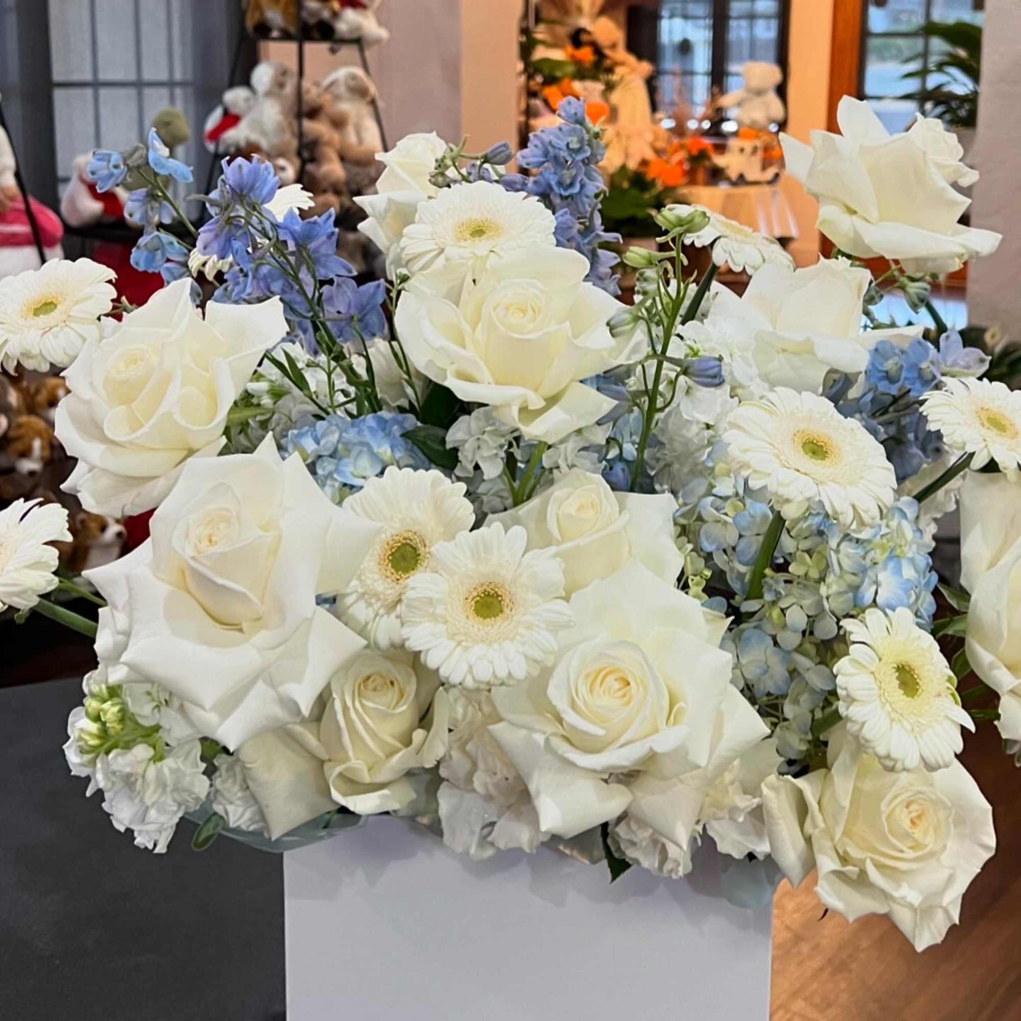 A mixed of Hydrangea, gerbera, roses, carnation, stock, and delphinium in blue
