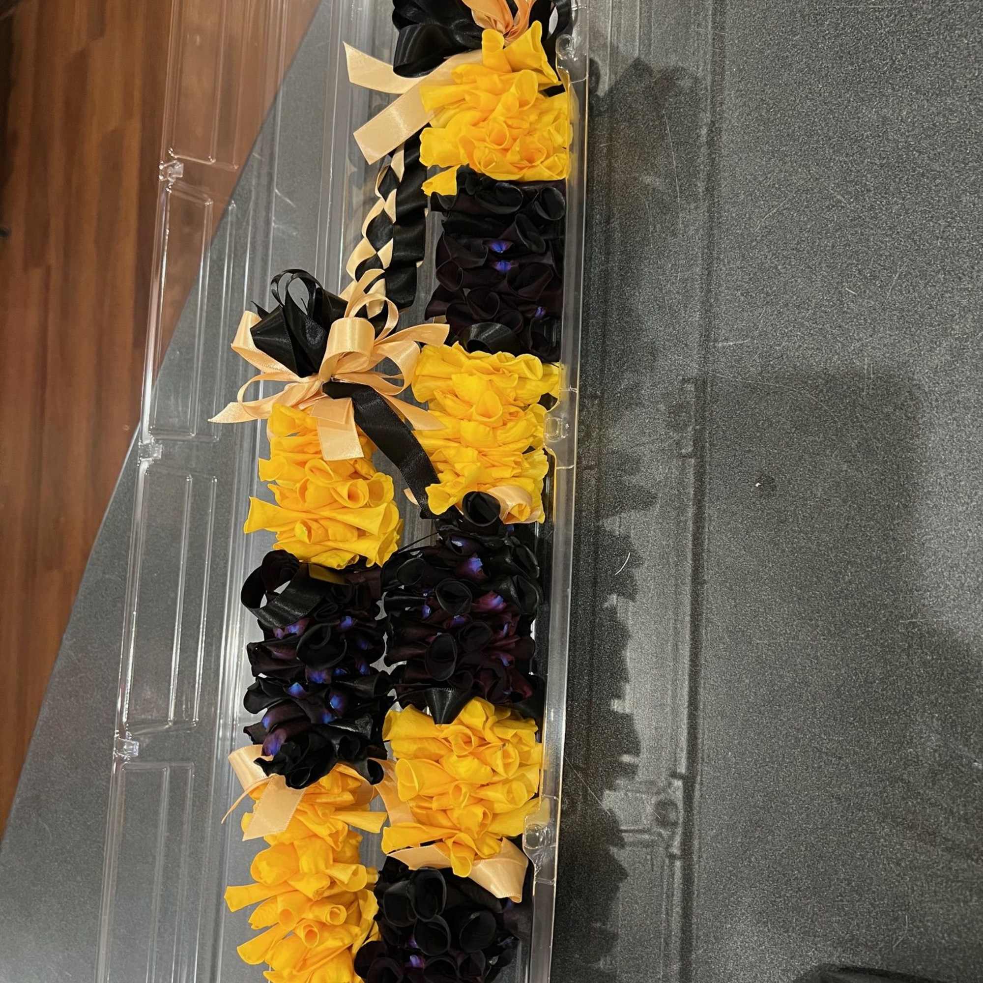 Black and yellow rose petals lei with black and gold ribbons, photo 2 of 2