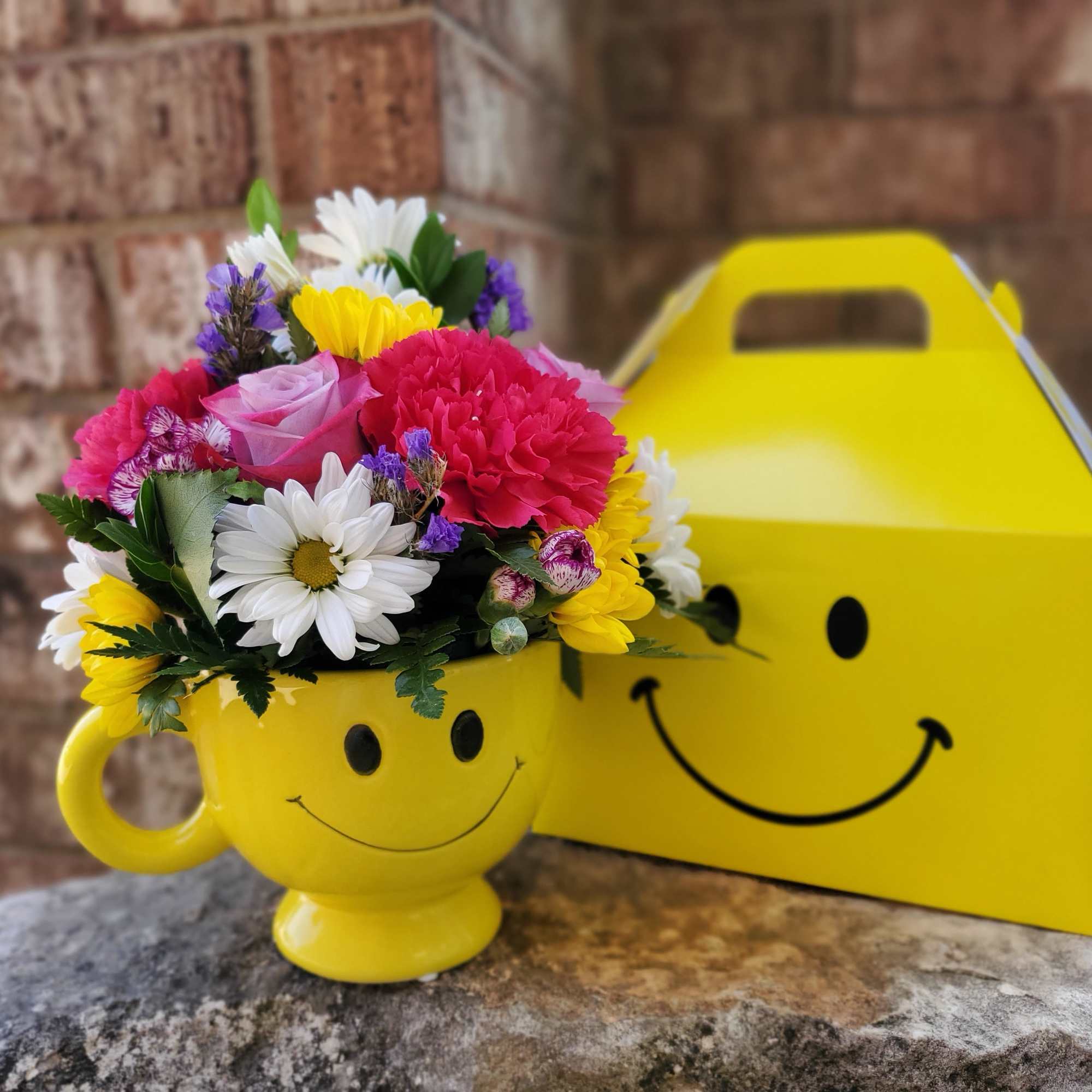 Colorful bouquet in a yellow smiley-face mug with a matching gift box