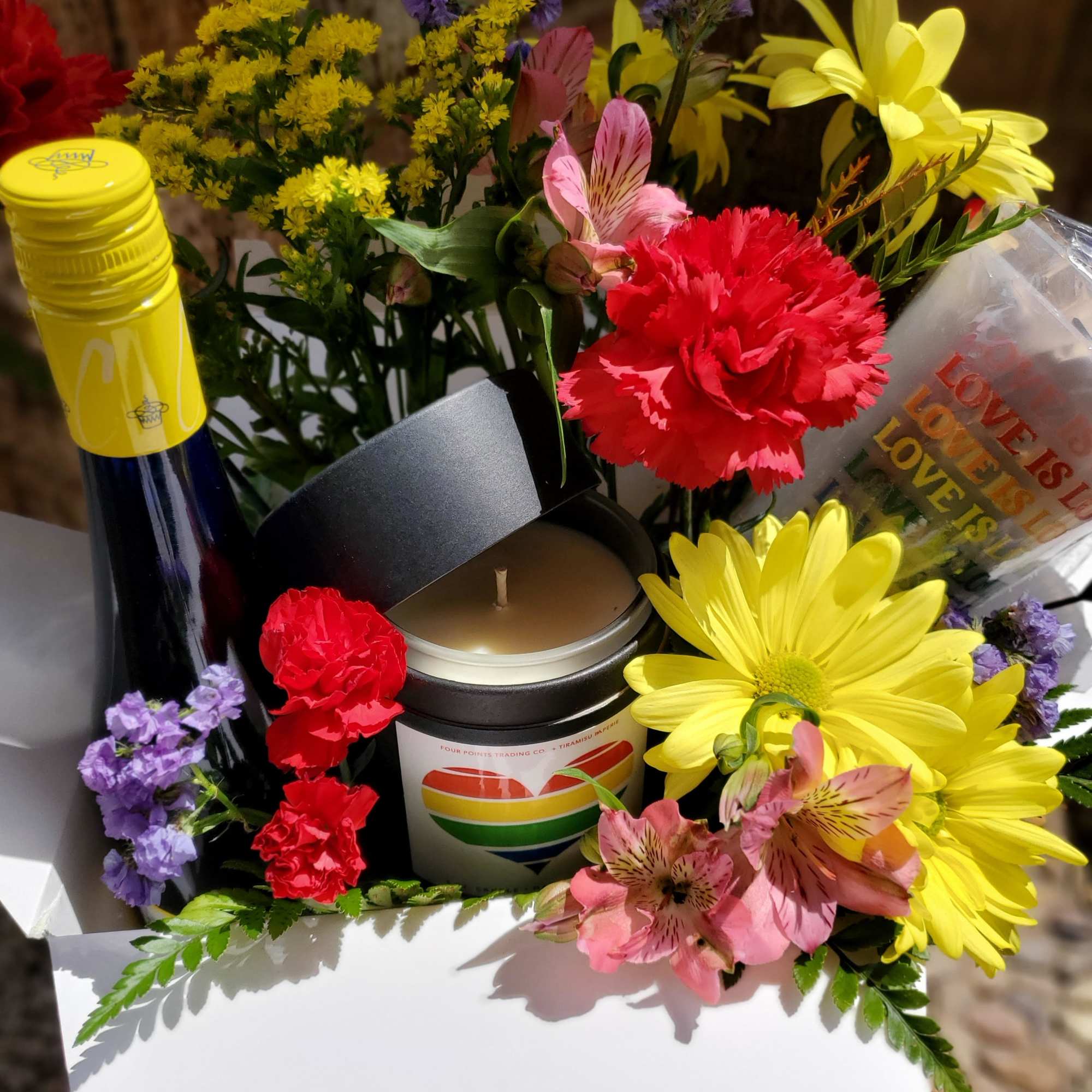 Gift box with flowers, a candle, and a bottle of wine