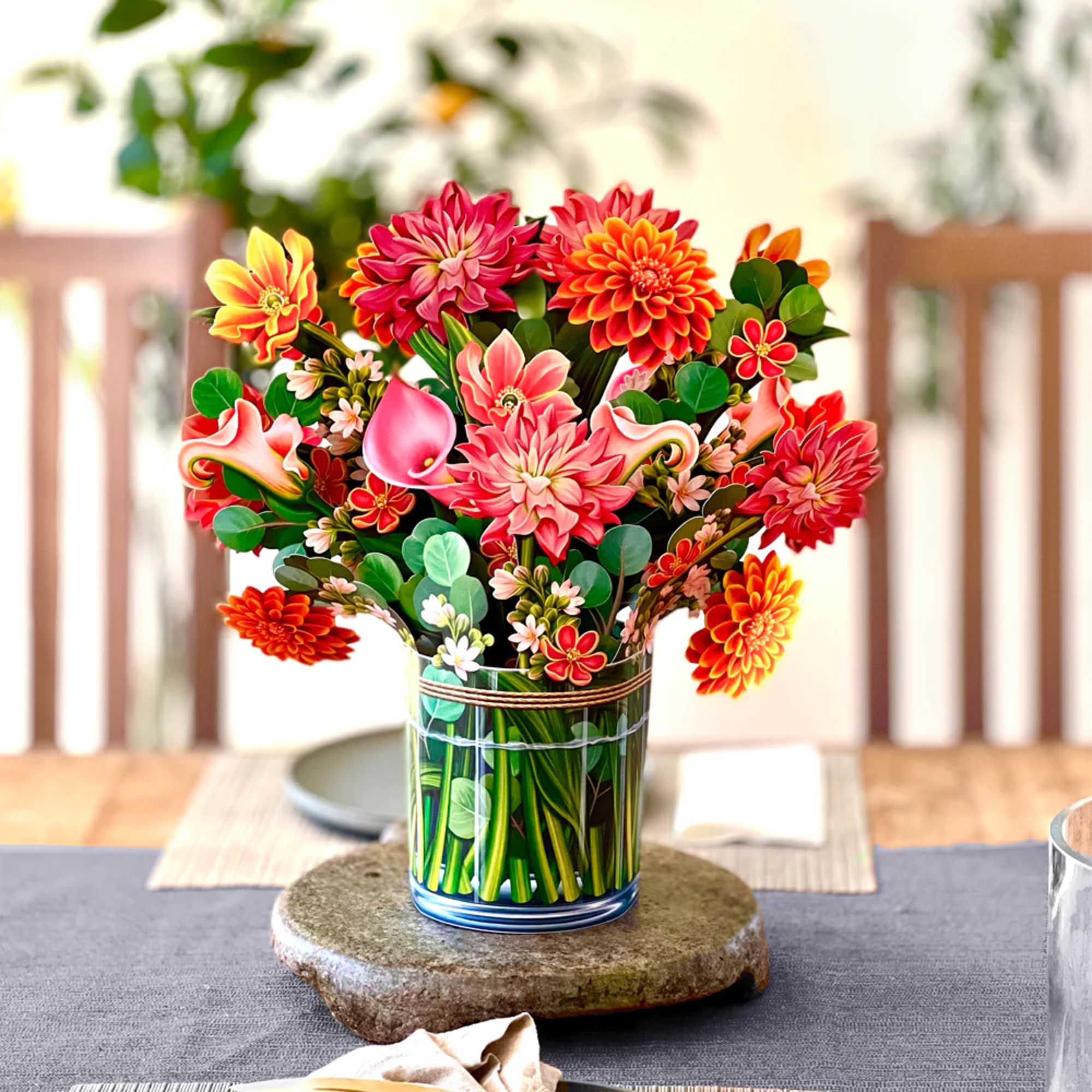 Bright mixed flower arrangement in a clear glass vase on a table