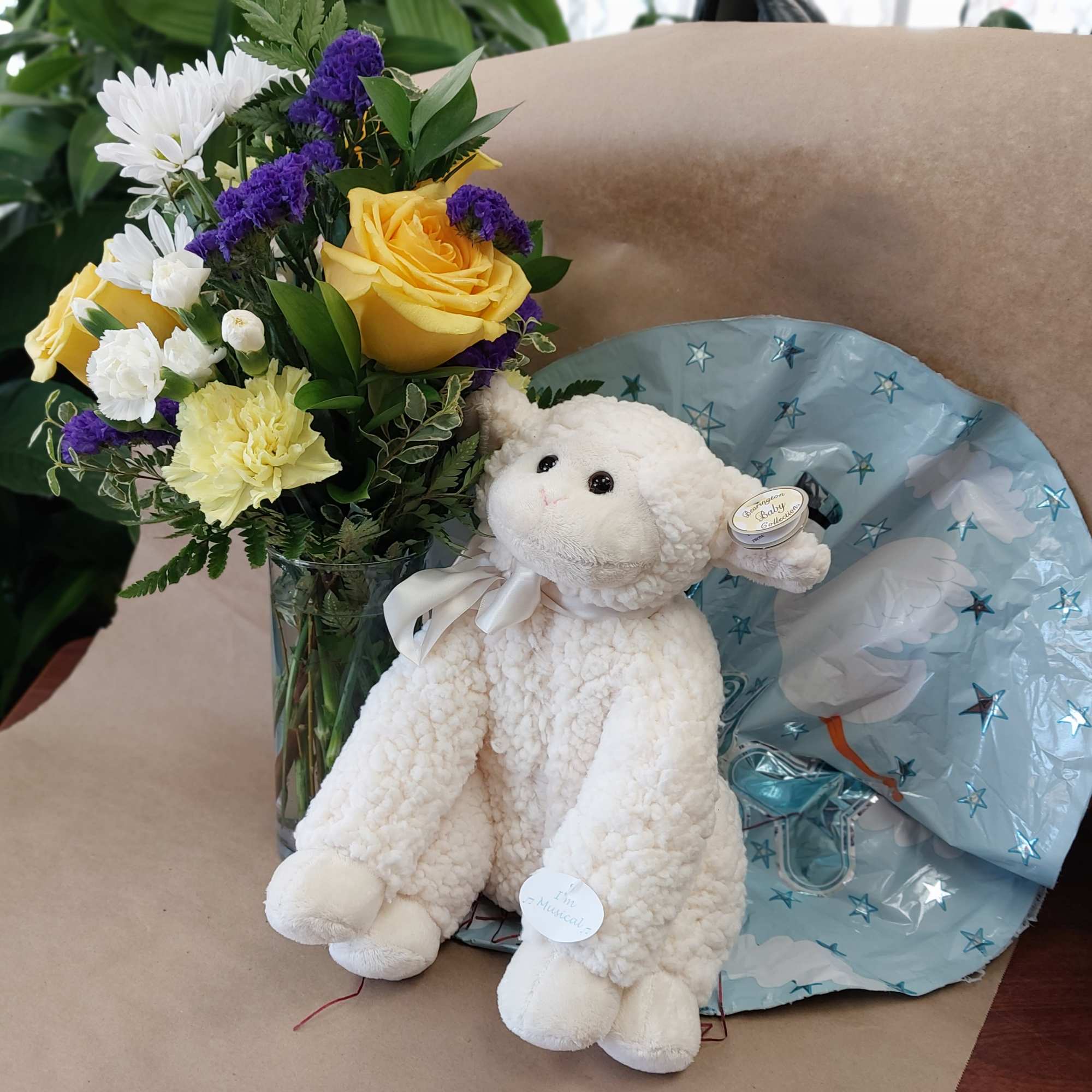 Bouquet of yellow roses and white flowers with a plush lamb and blue balloon