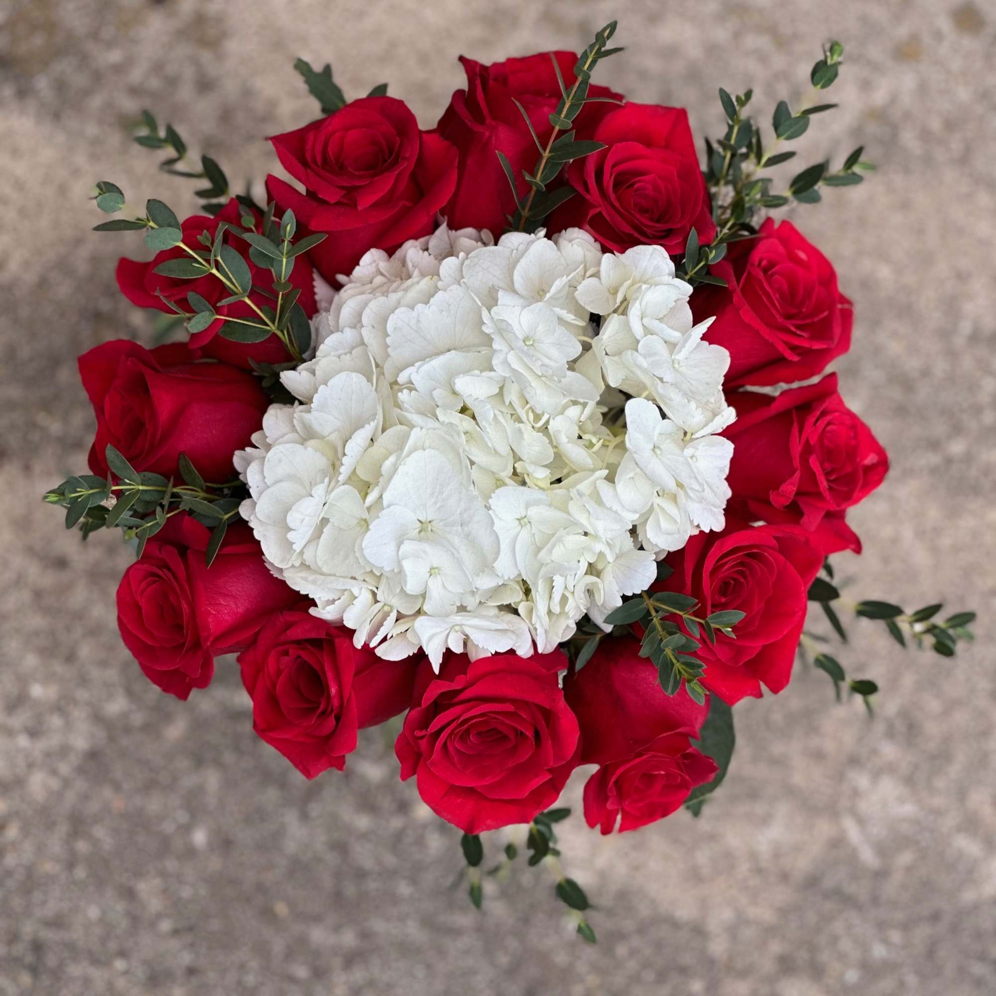 Red roses surrounding a white hydrangea bouquet