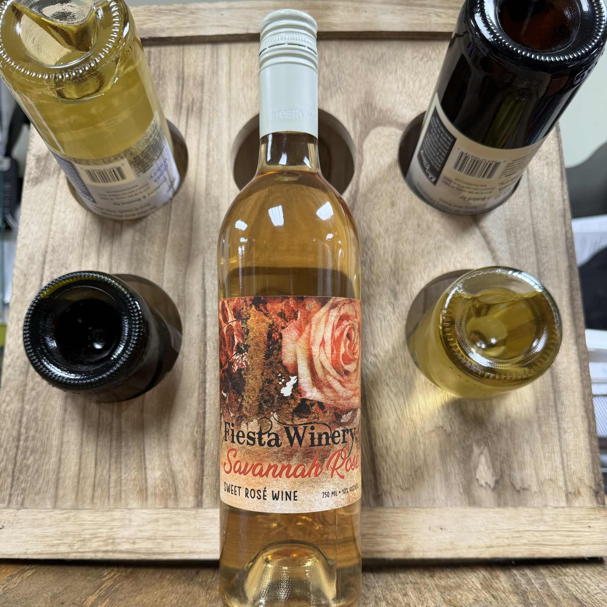 Five bottles of rosé wine arranged in a wooden carrier