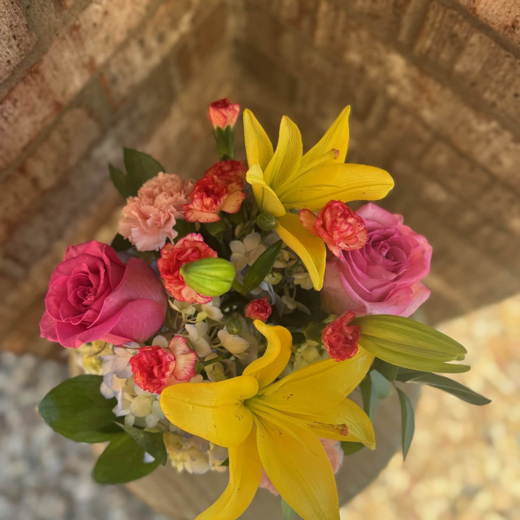 Bouquet of pink roses, yellow lilies, and small carnations