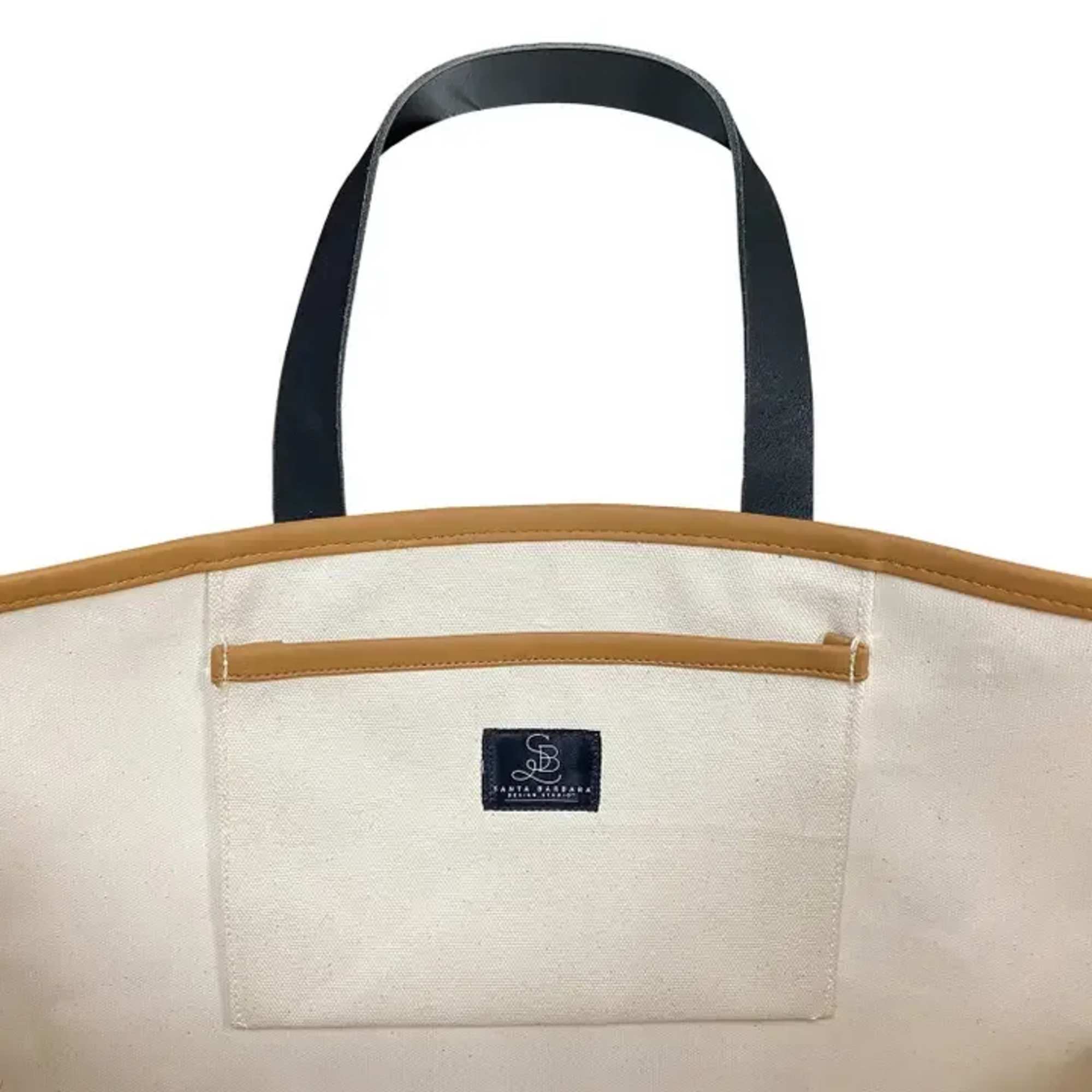 Canvas tote bag with black handles and tan trim
