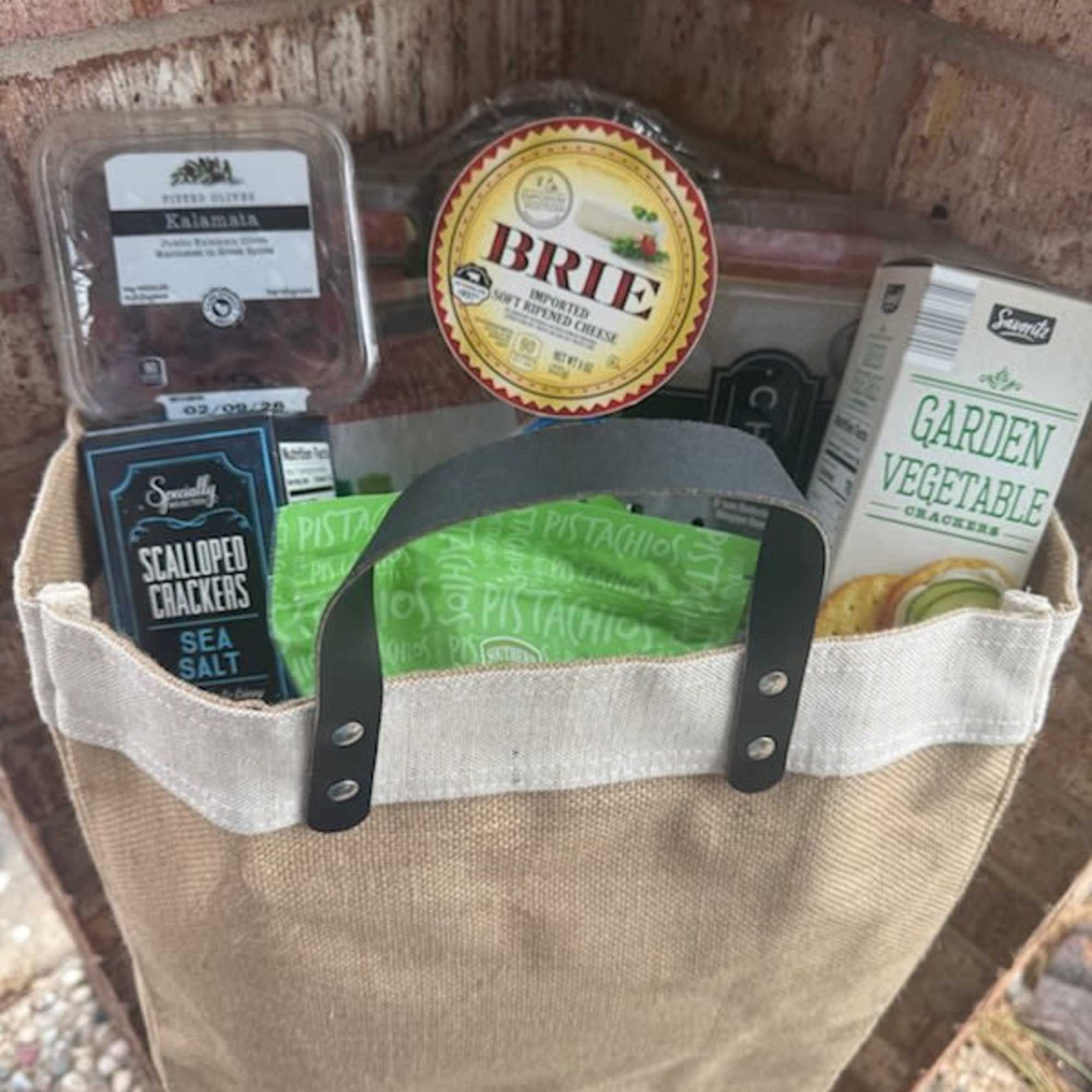 Gift basket with assorted crackers and cheese in a tote bag