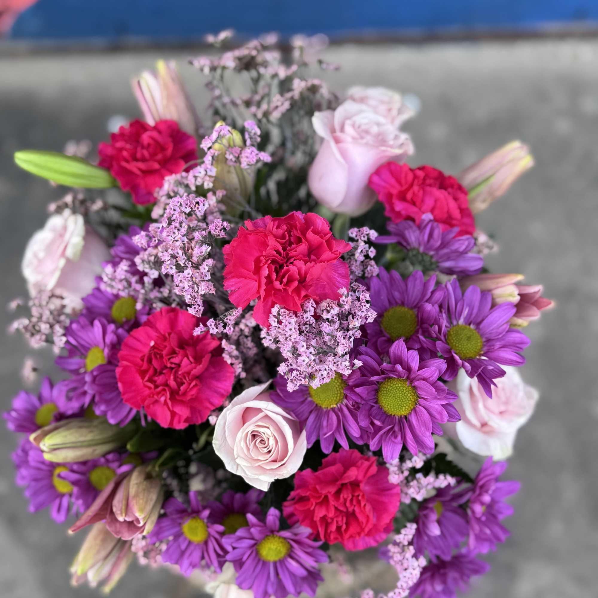 Bouquet of pink roses, purple daisies, and hot pink carnations