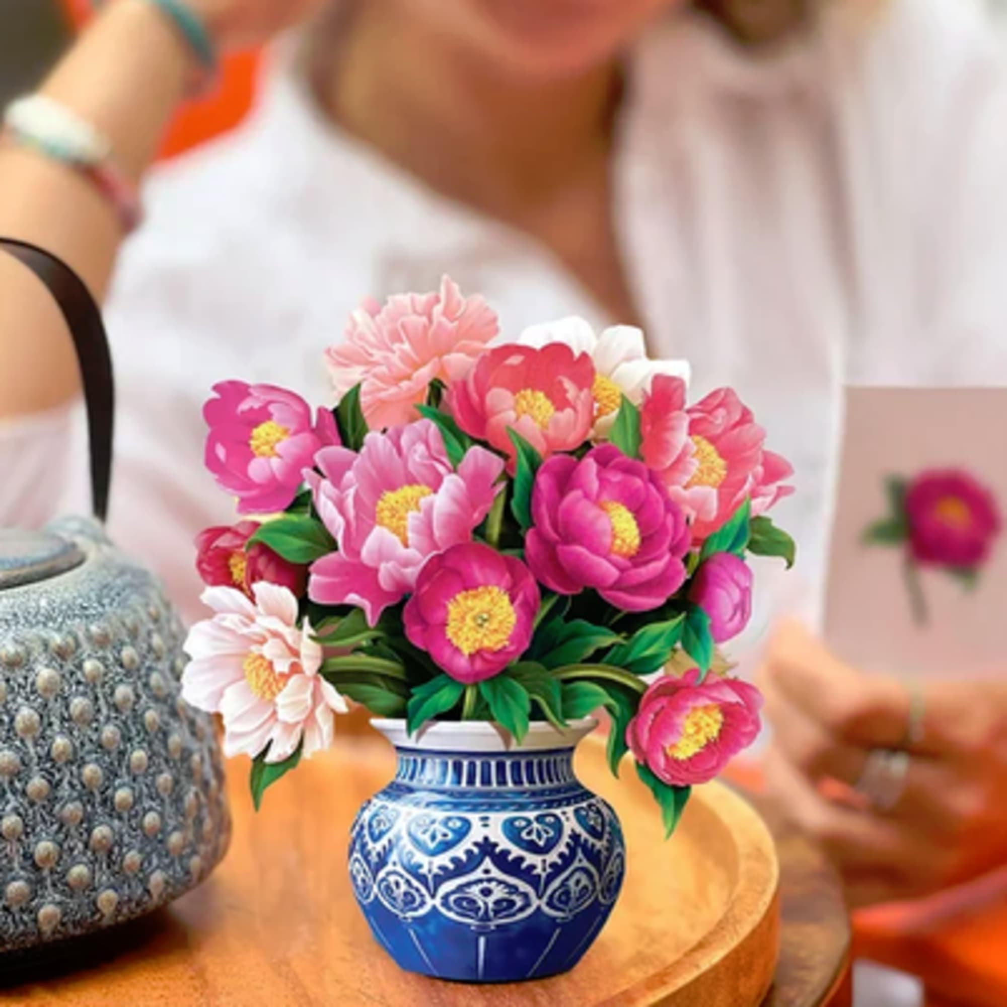 Pink and white flowers arranged in a blue patterned vase