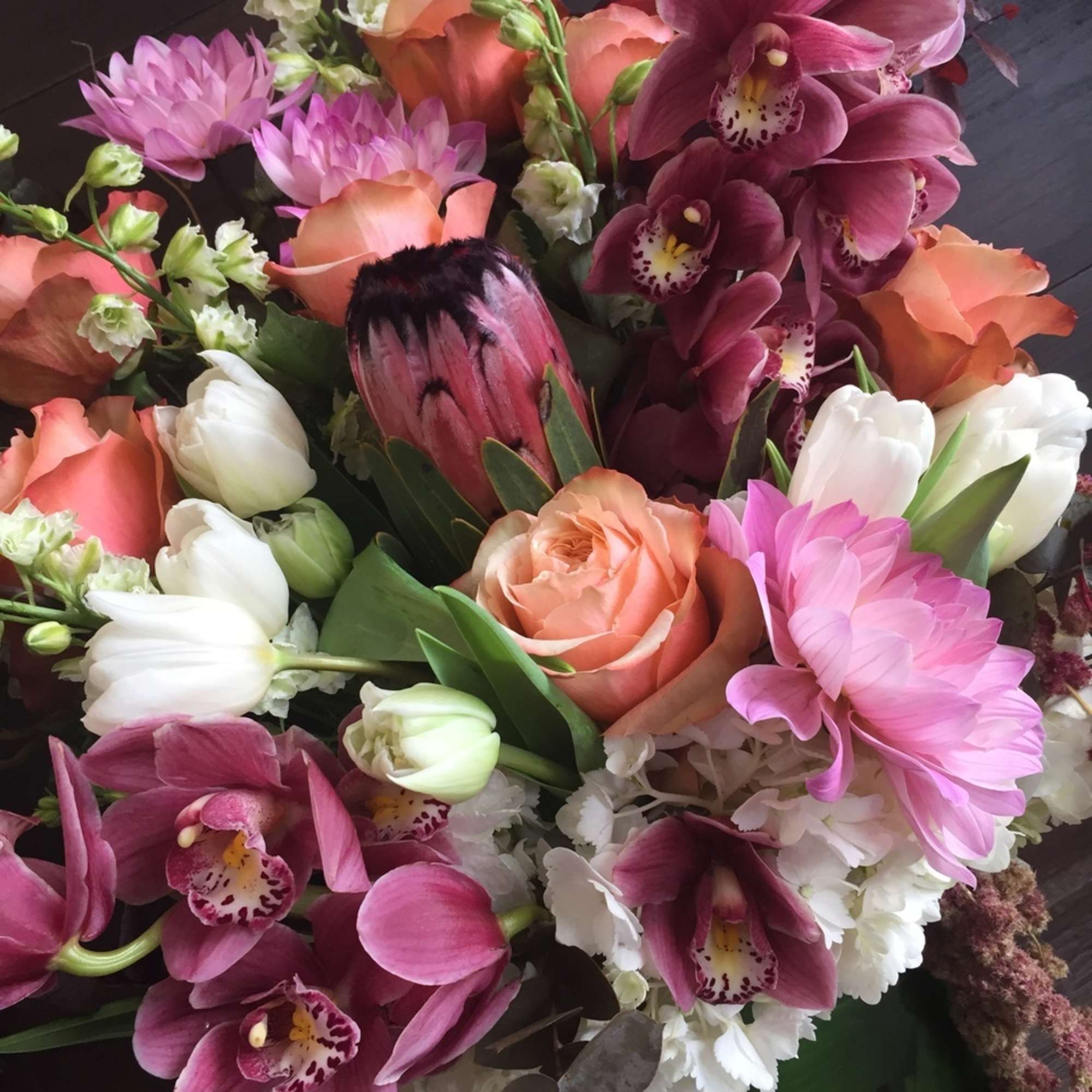 Filled with dahlias, orchids, protea, hydrangeas, tulips and roses, this design is