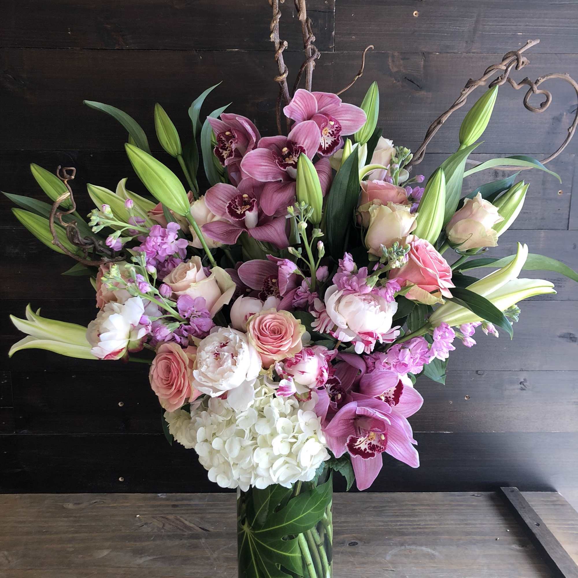 Pink and white floral arrangement in a tall glass vase
