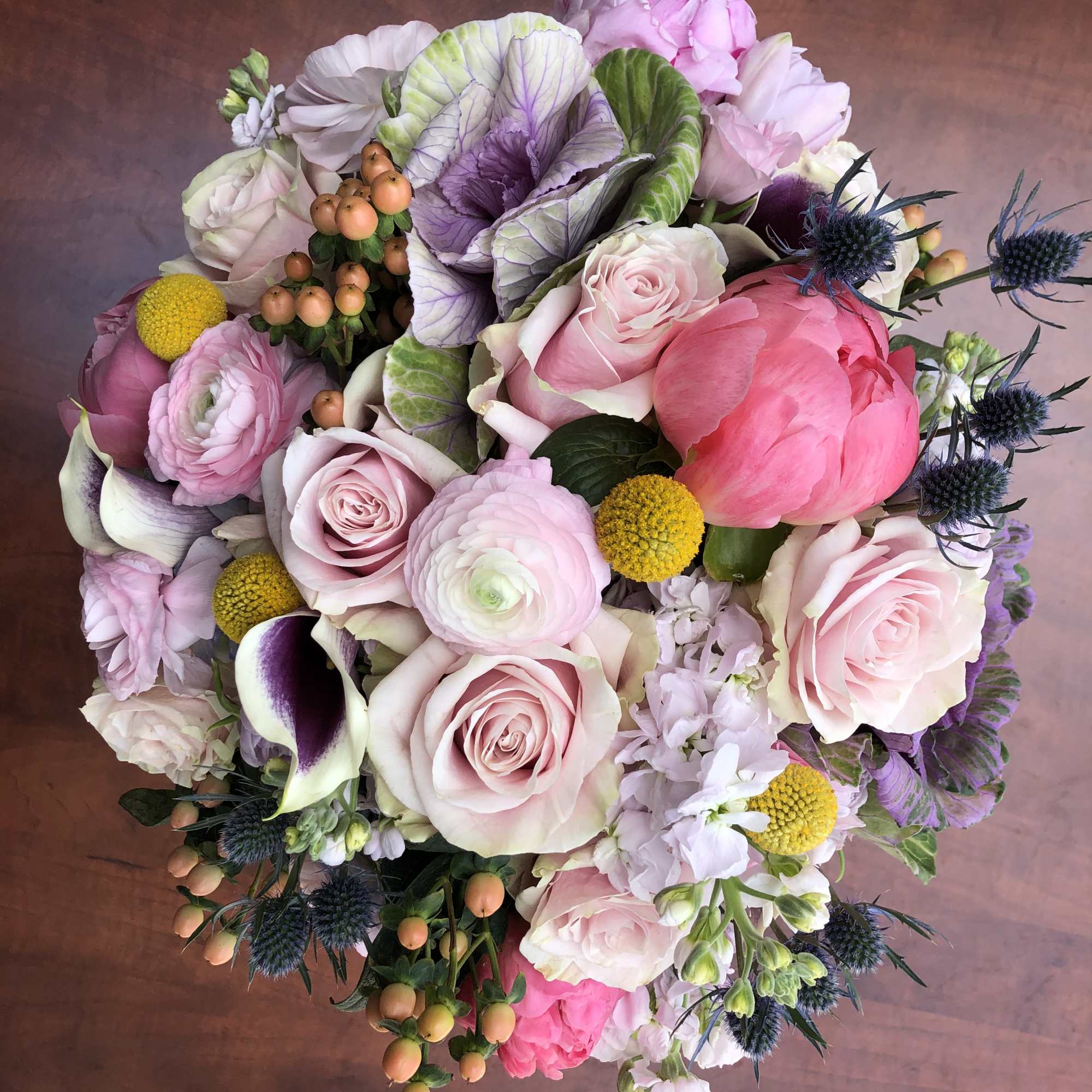 Round bouquet of pink and white flowers with purple accents
