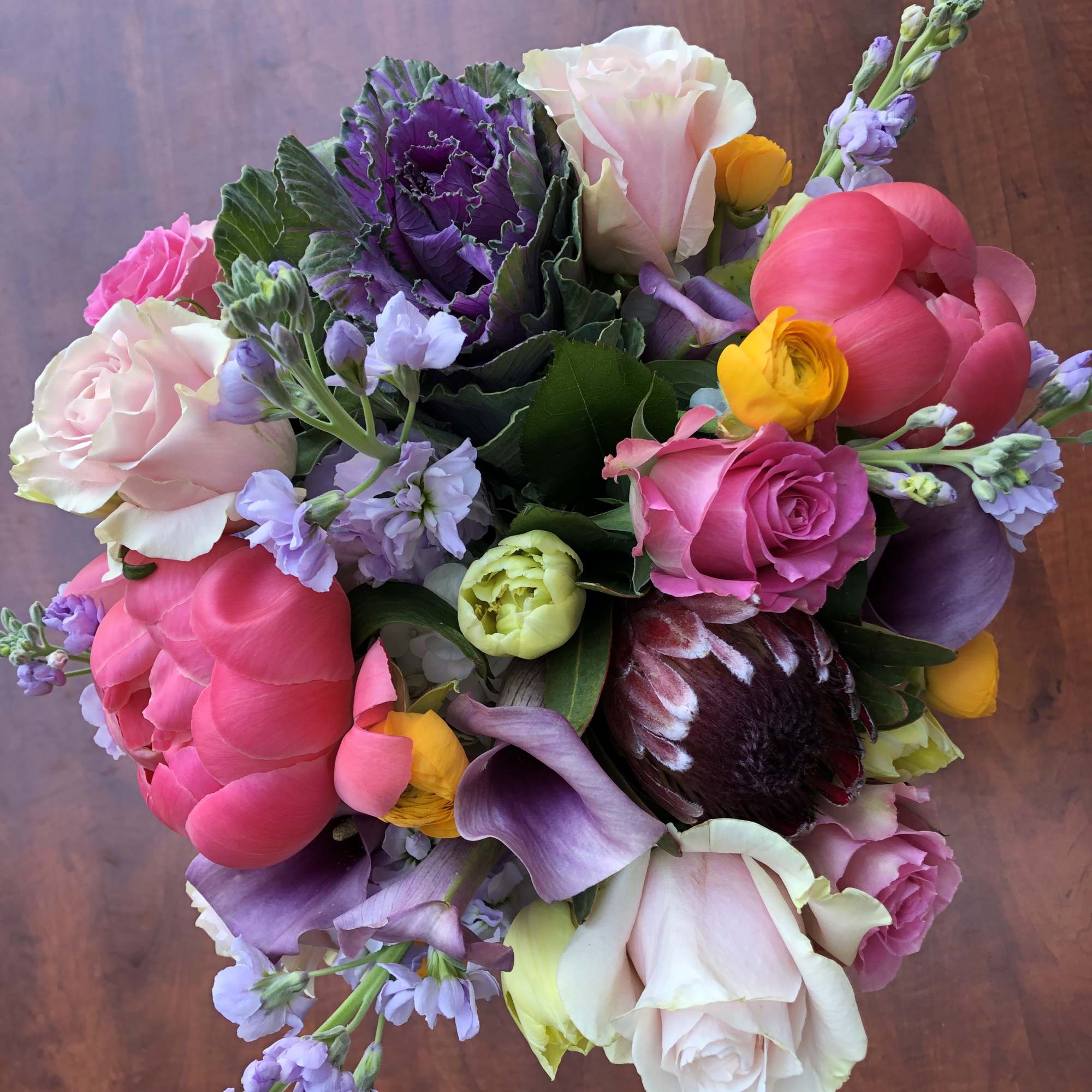 Mixed bouquet with pink roses, purple blooms, and yellow flowers