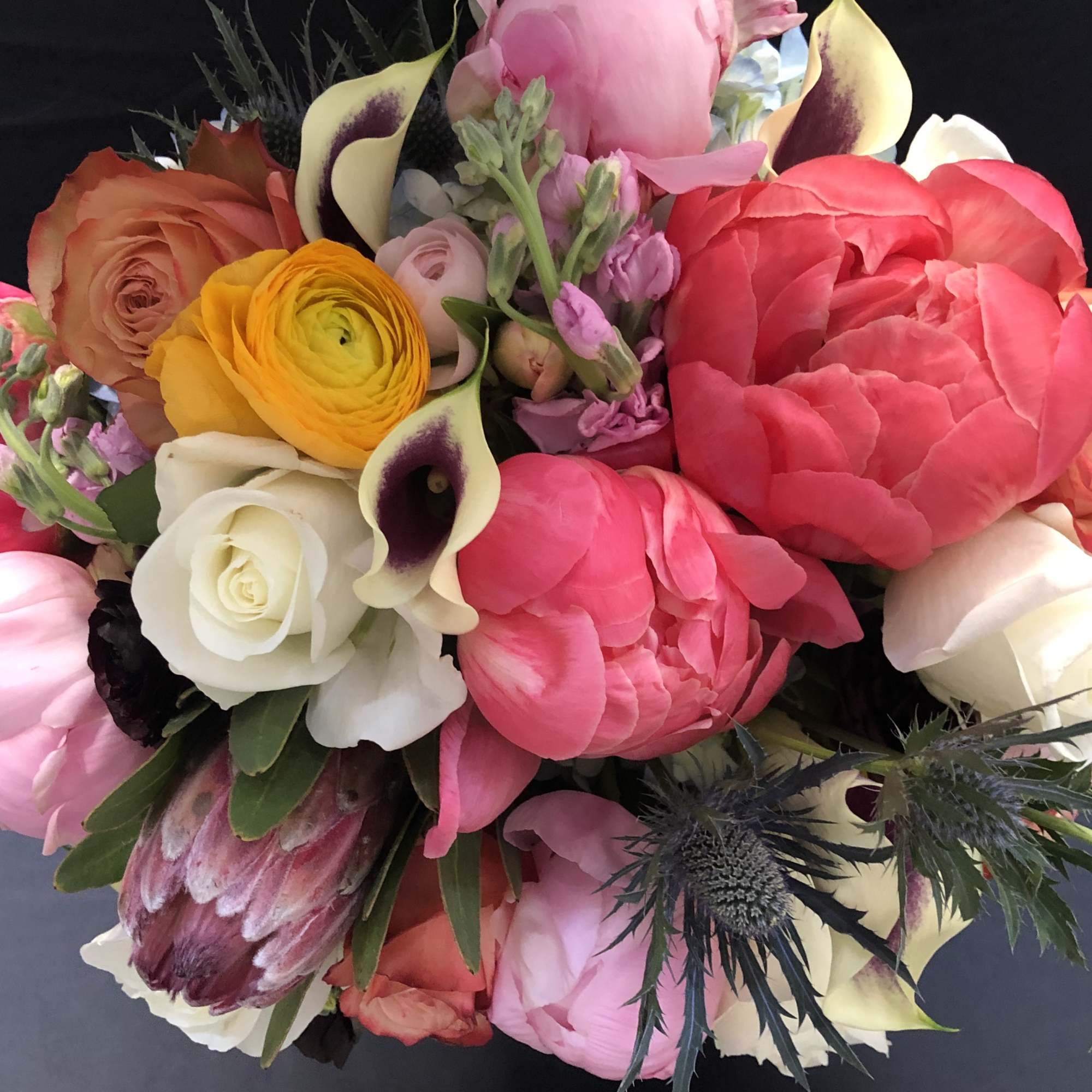Mixed bouquet of pink, white, and yellow flowers with calla lilies and roses