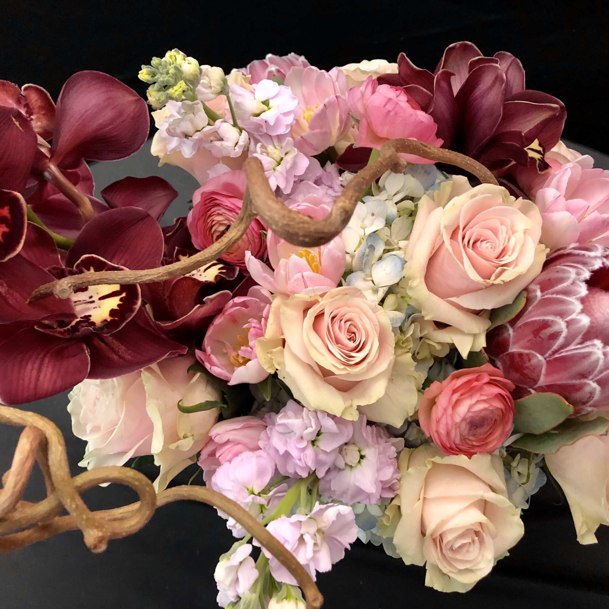 Bouquet of pink and burgundy flowers with twisted branches