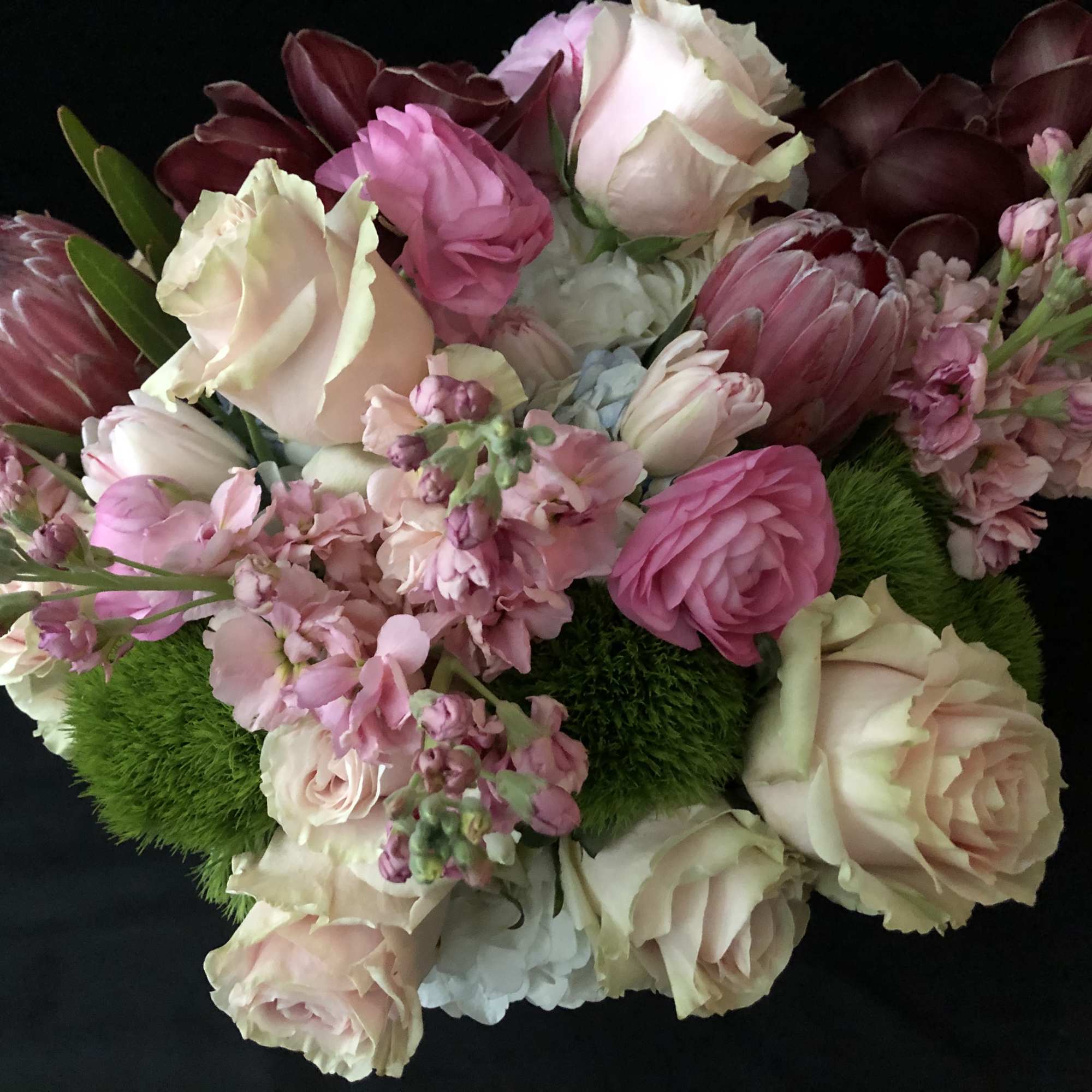 Bouquet of pink and cream roses with mixed blooms on a black background