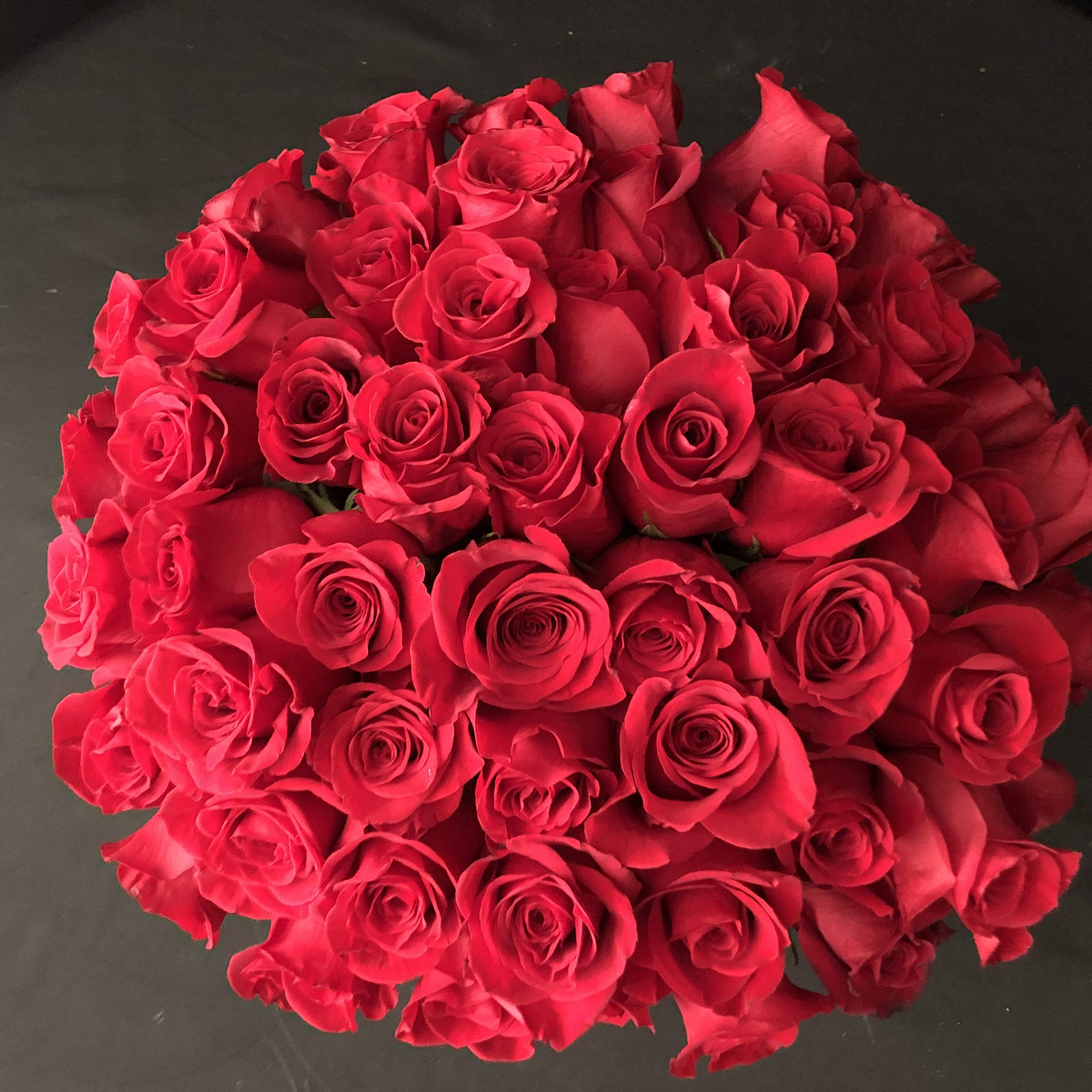 Round bouquet of red roses on a dark background