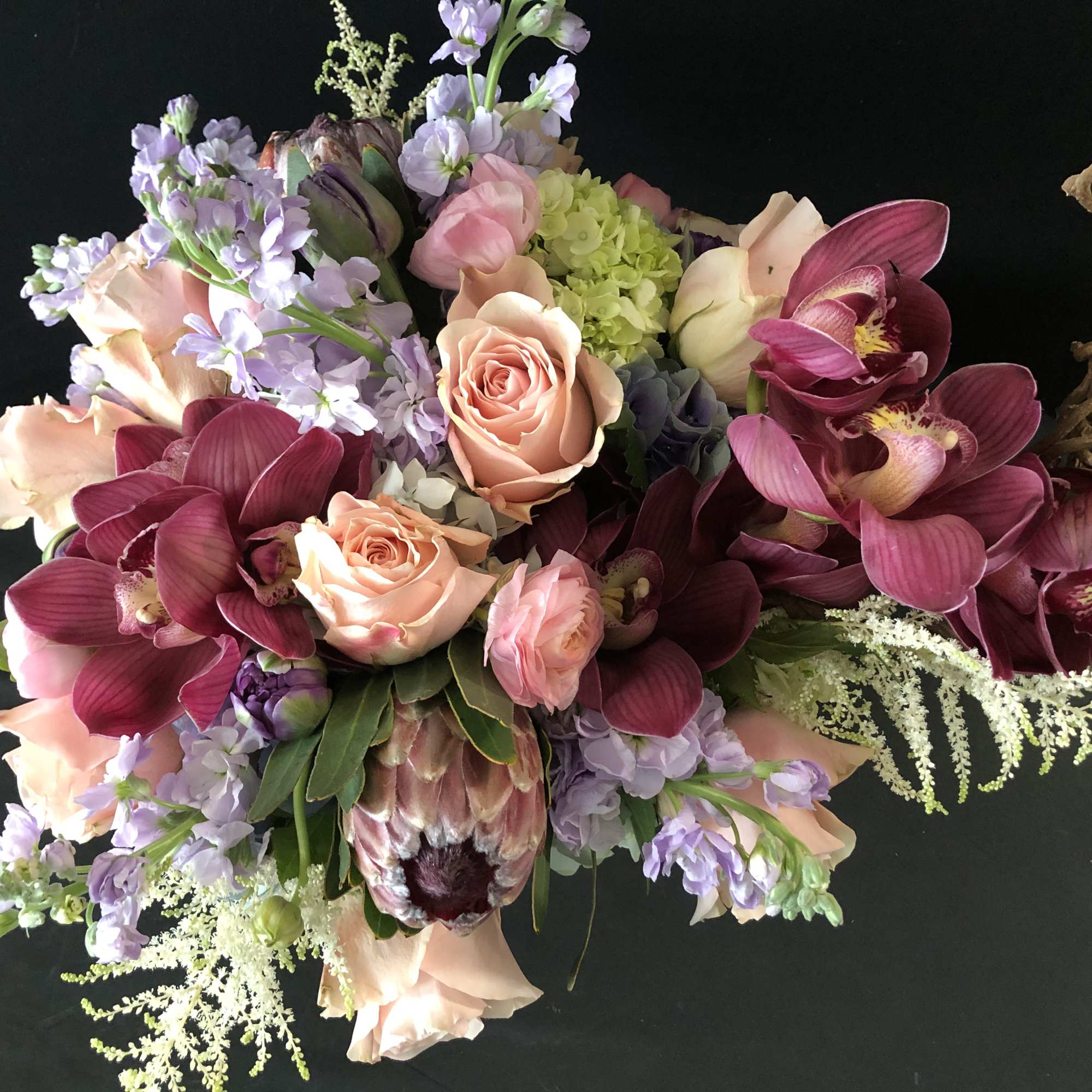 Bouquet of peach roses, purple orchids, and lavender flowers