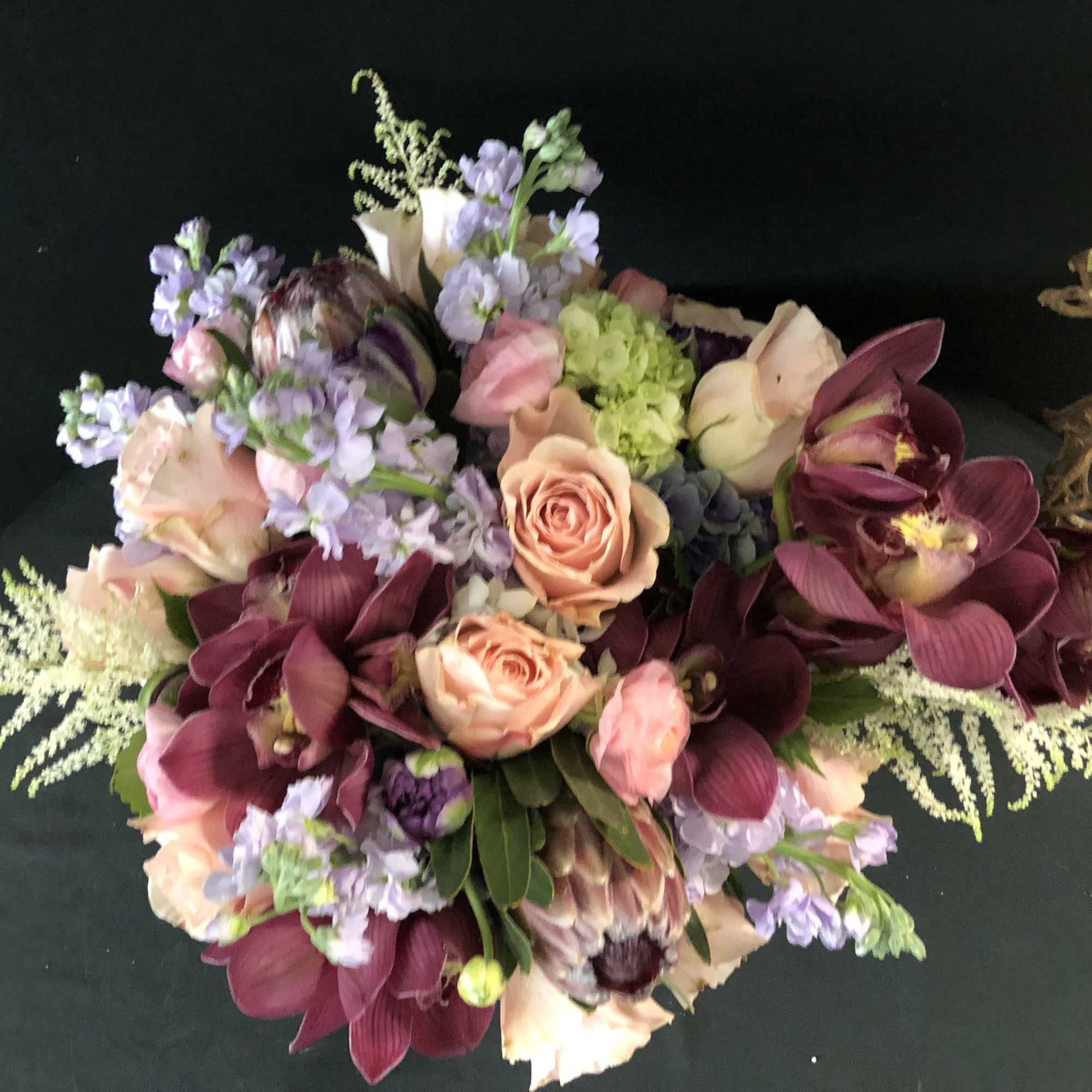 Bouquet of pink roses, purple orchids, and lavender flowers