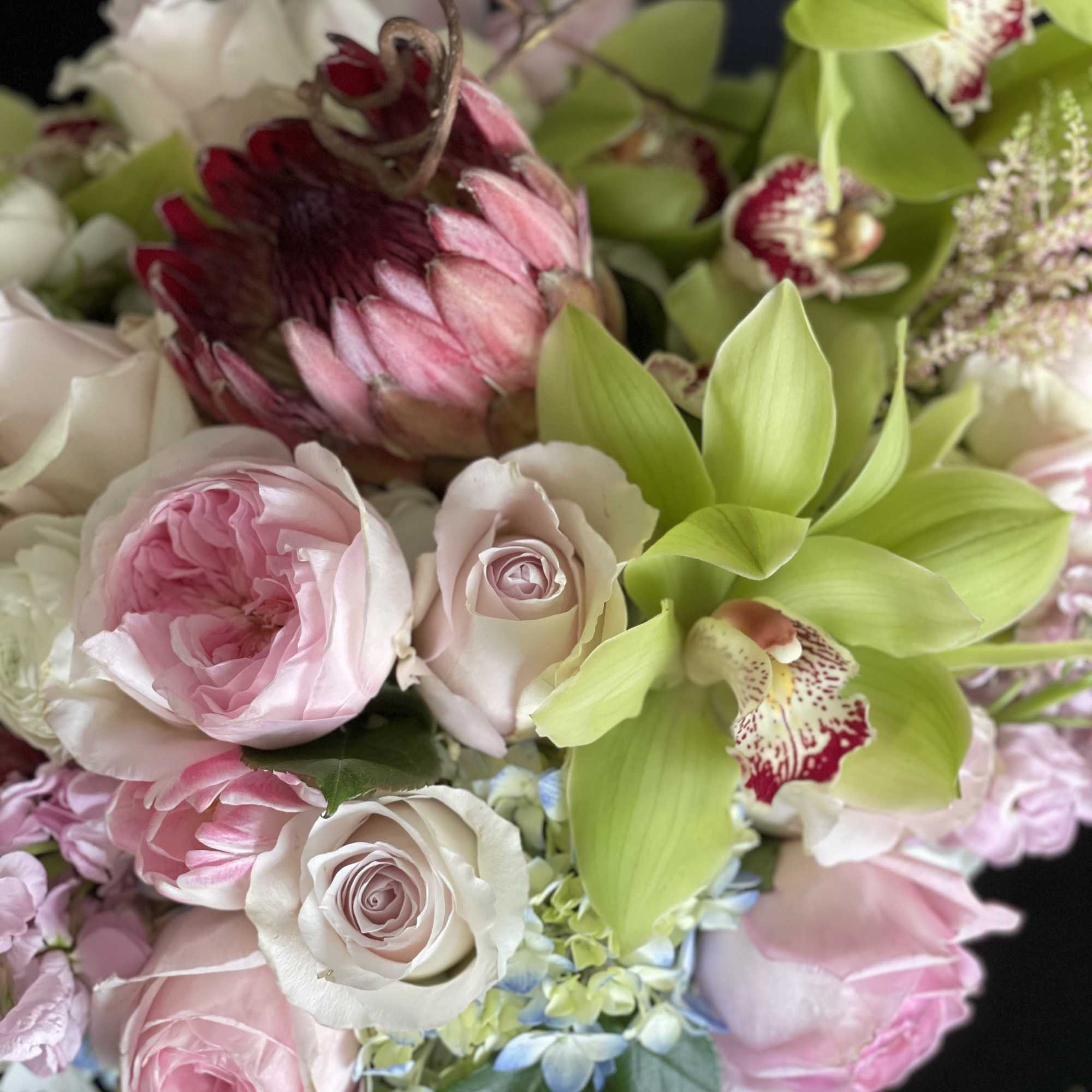 Bouquet of pink and white roses with green orchids