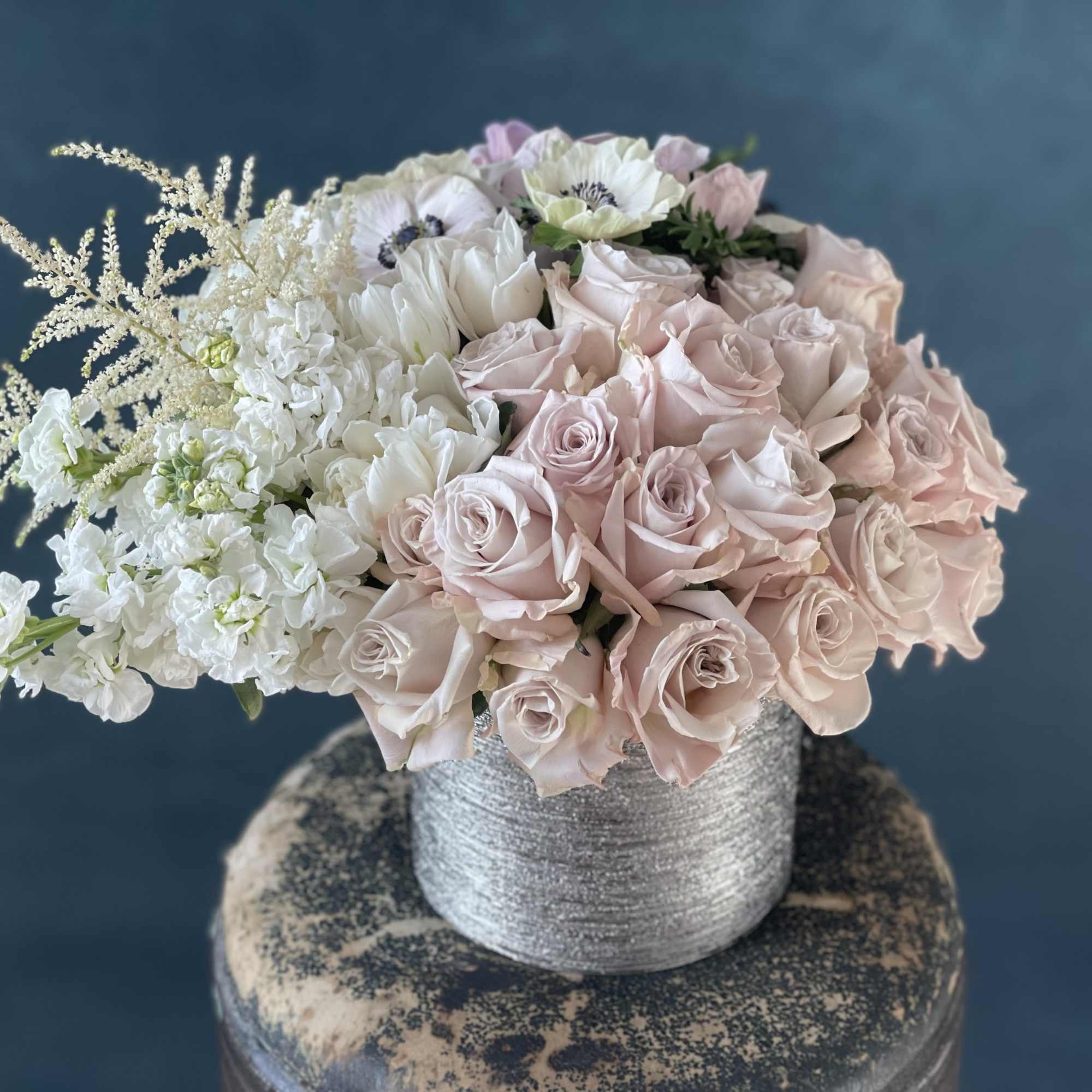 Bouquet of pale pink and white roses in a silver vase