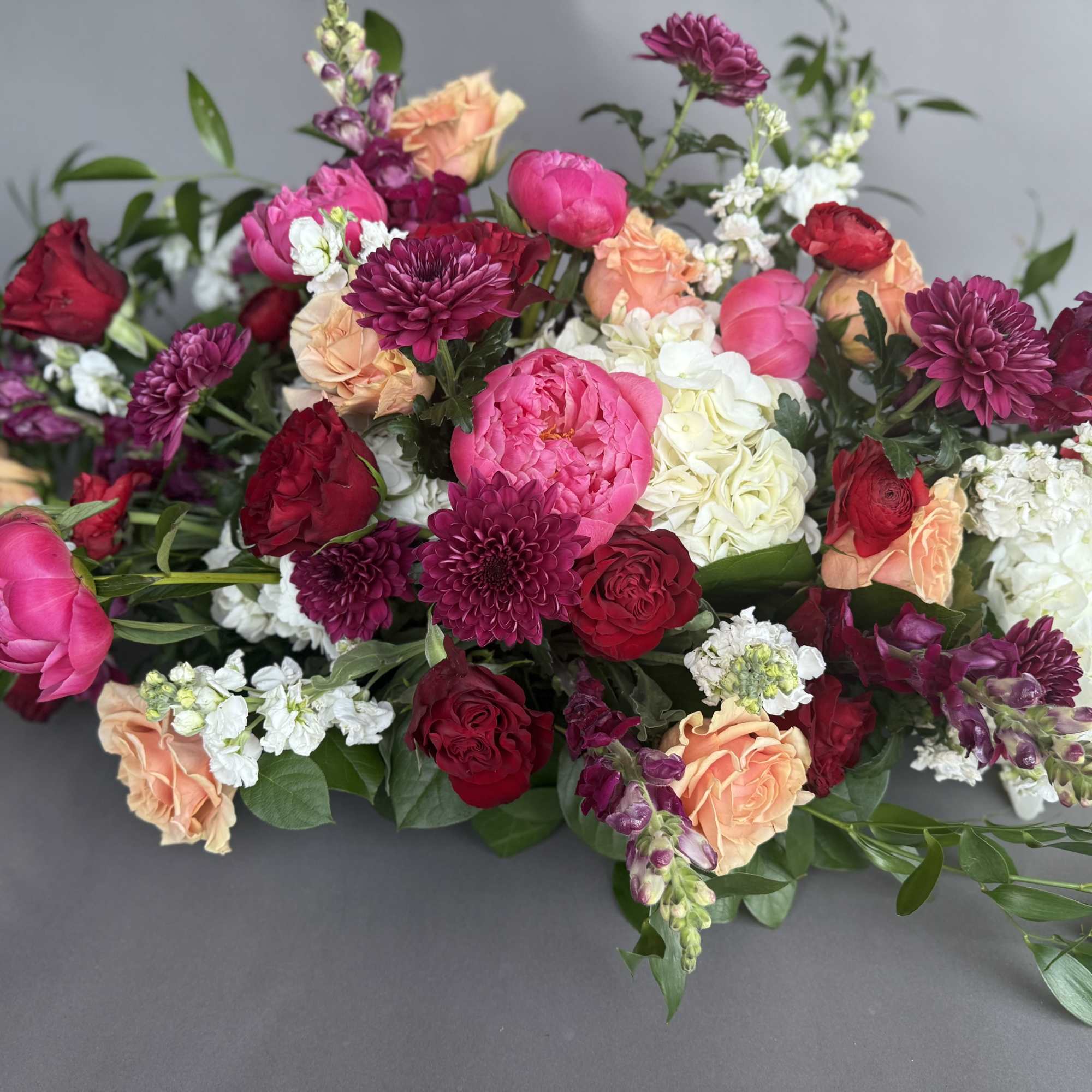 Low arrangement of pink, red, peach, and white flowers