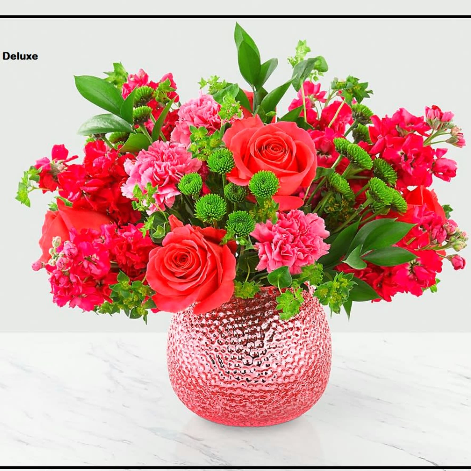 Pink and red flower arrangement in a textured glass vase