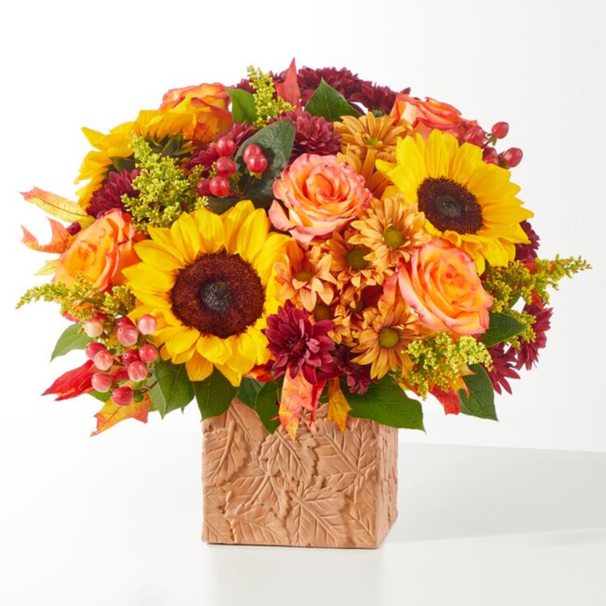 Autumn bouquet with sunflowers, roses, and mums in a textured square vase