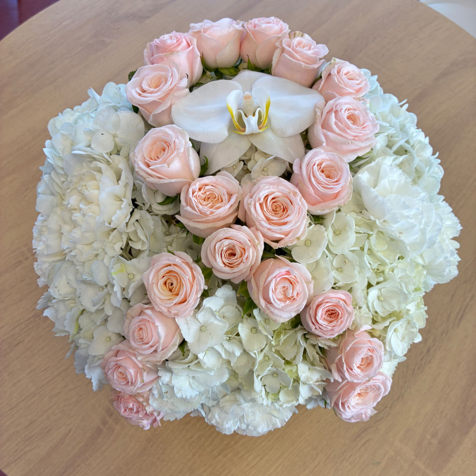 Round bouquet of pale pink roses and white hydrangeas with a white orchid center, photo 2 of 2