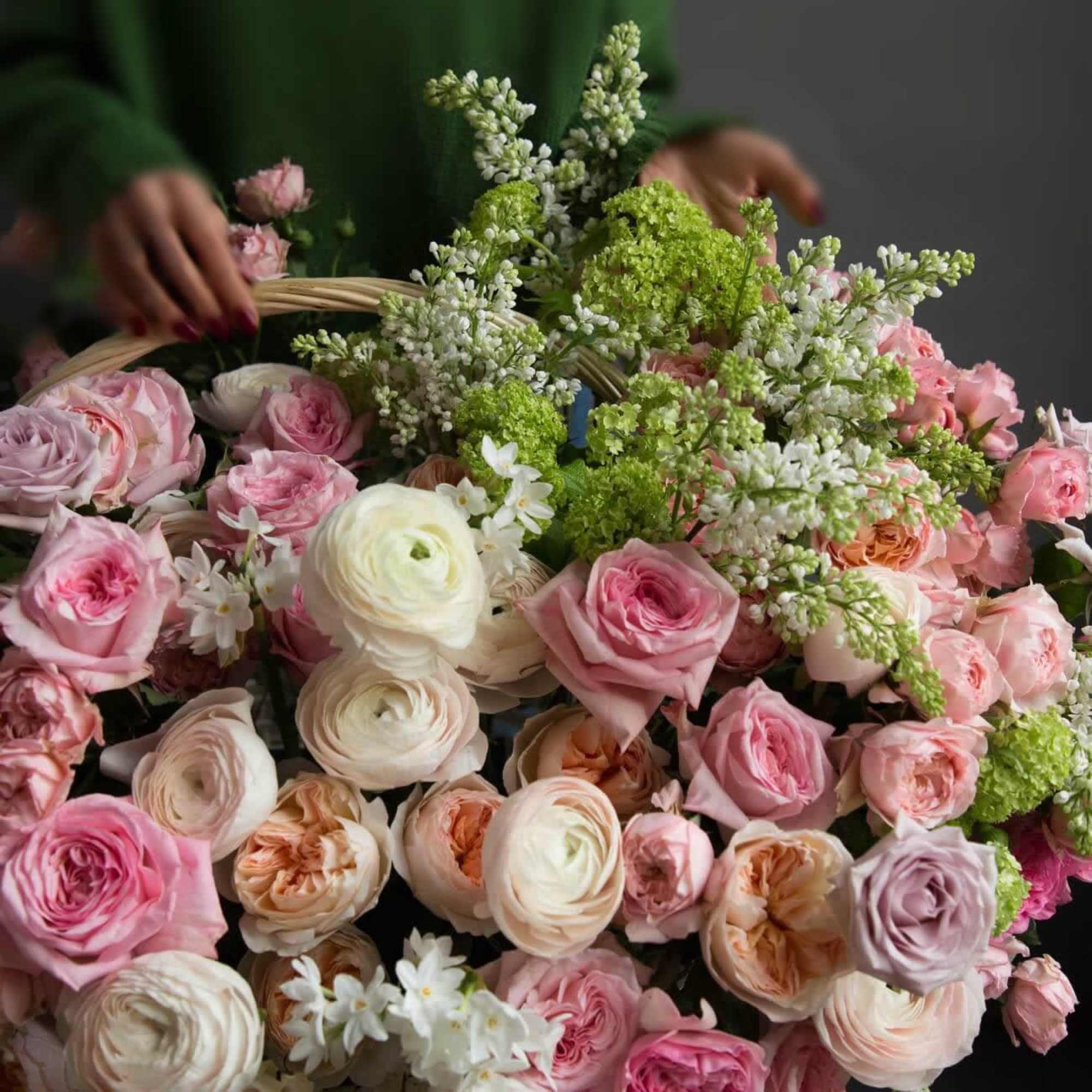 Basket of pink and cream roses with white filler flowers