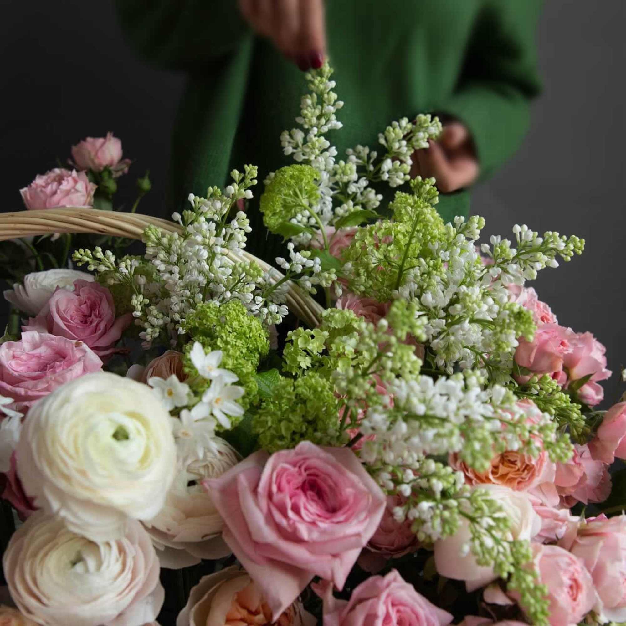 Basket of pink and white roses with green and white filler flowers