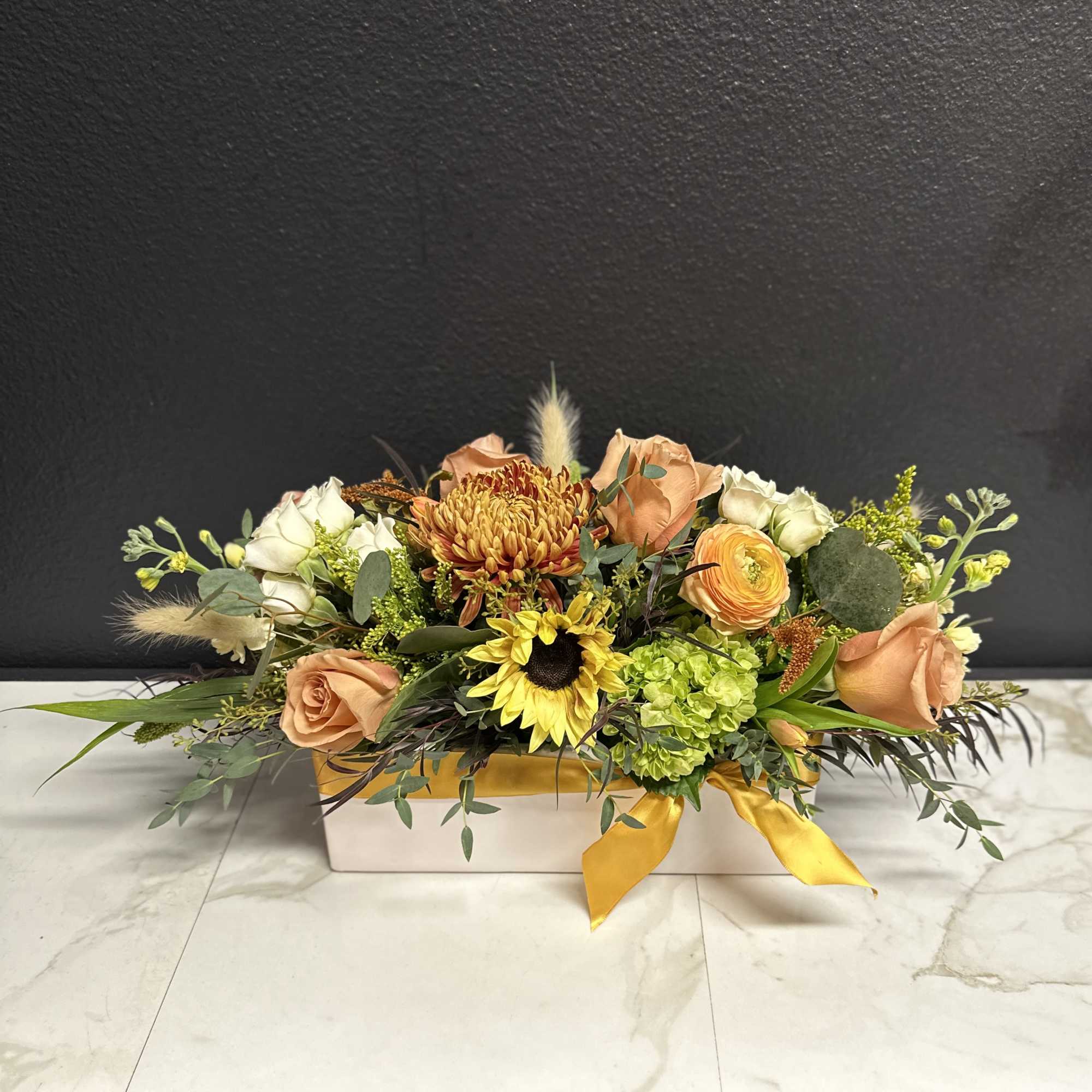 Low floral arrangement with peach roses, yellow sunflower, and green hydrangea in a white box