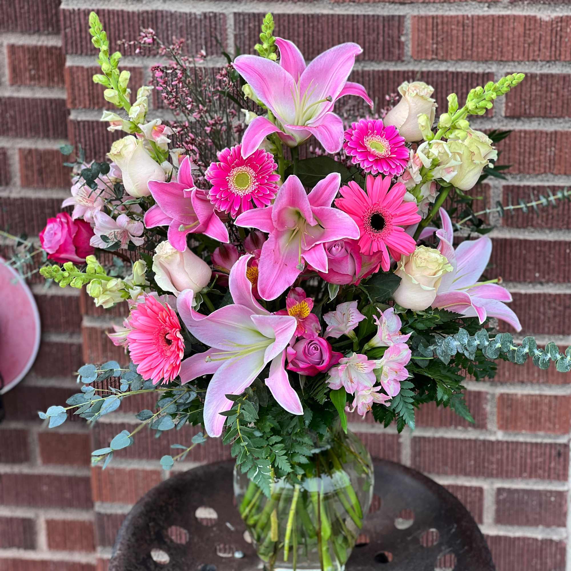 Pink lilies and gerbera daisies in a clear glass vase