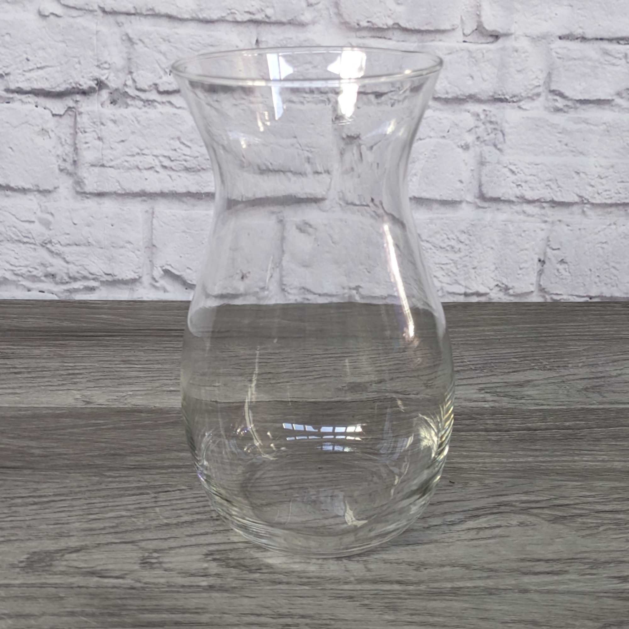 Clear glass vase with a flared top and rounded base
