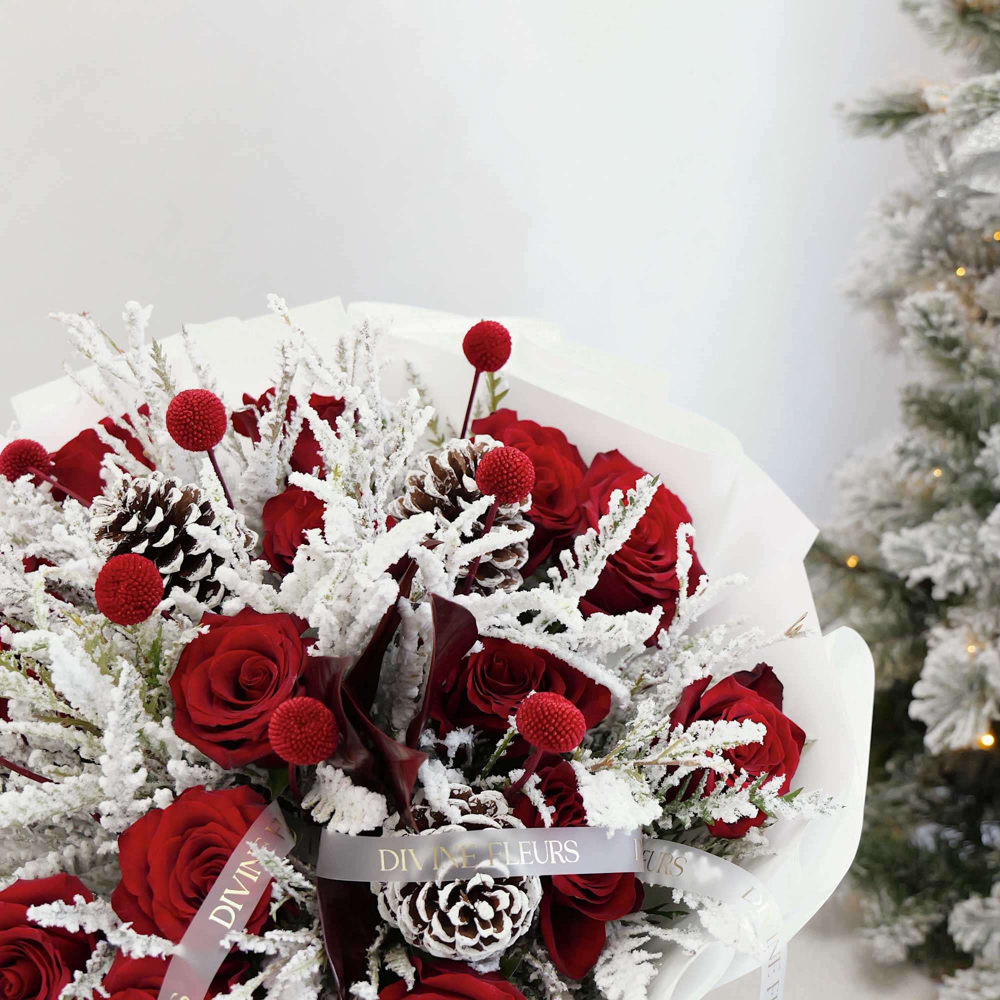 Bouquet of red roses with frosted pinecones and white winter accents