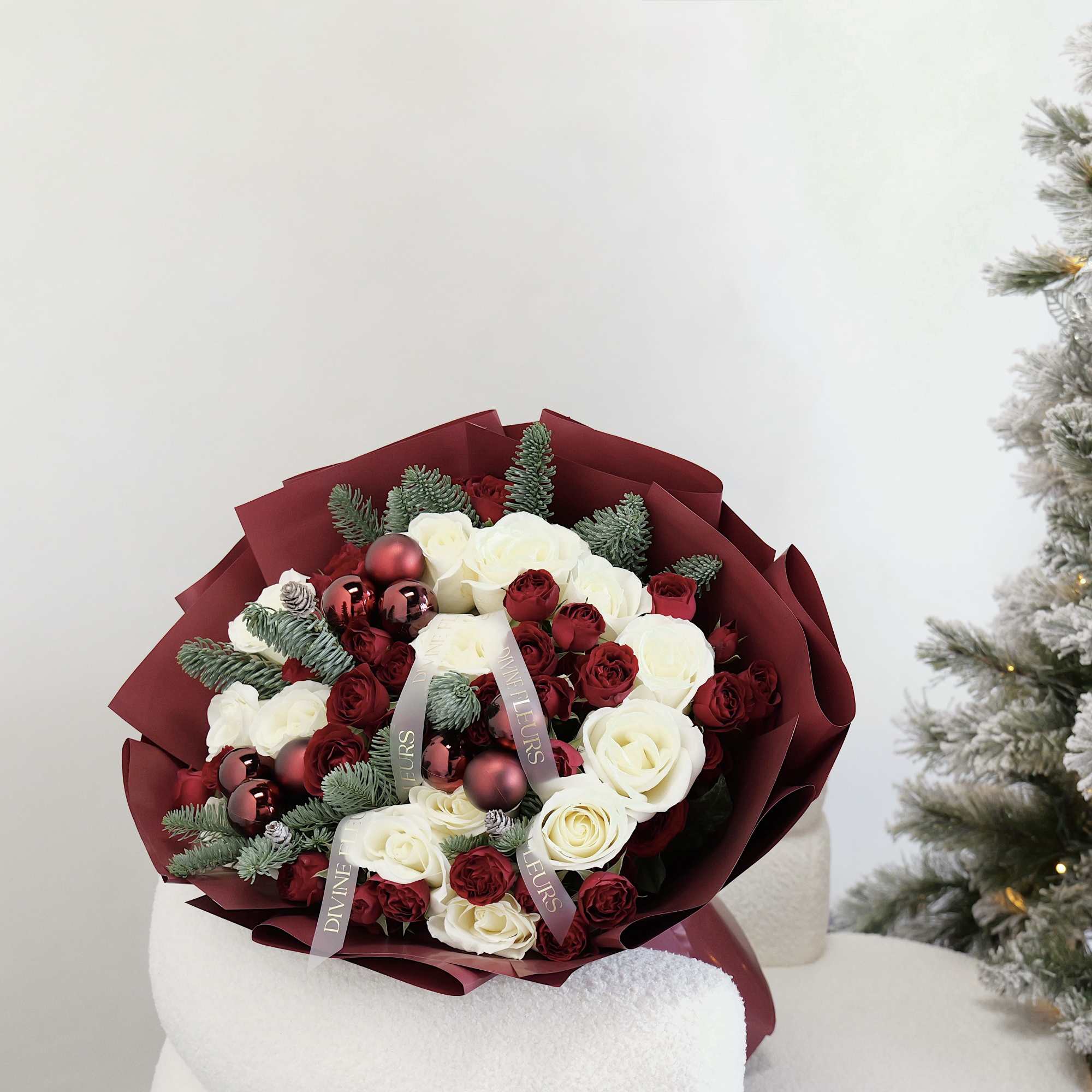 Bouquet of red and white roses with ornaments and evergreen sprigs