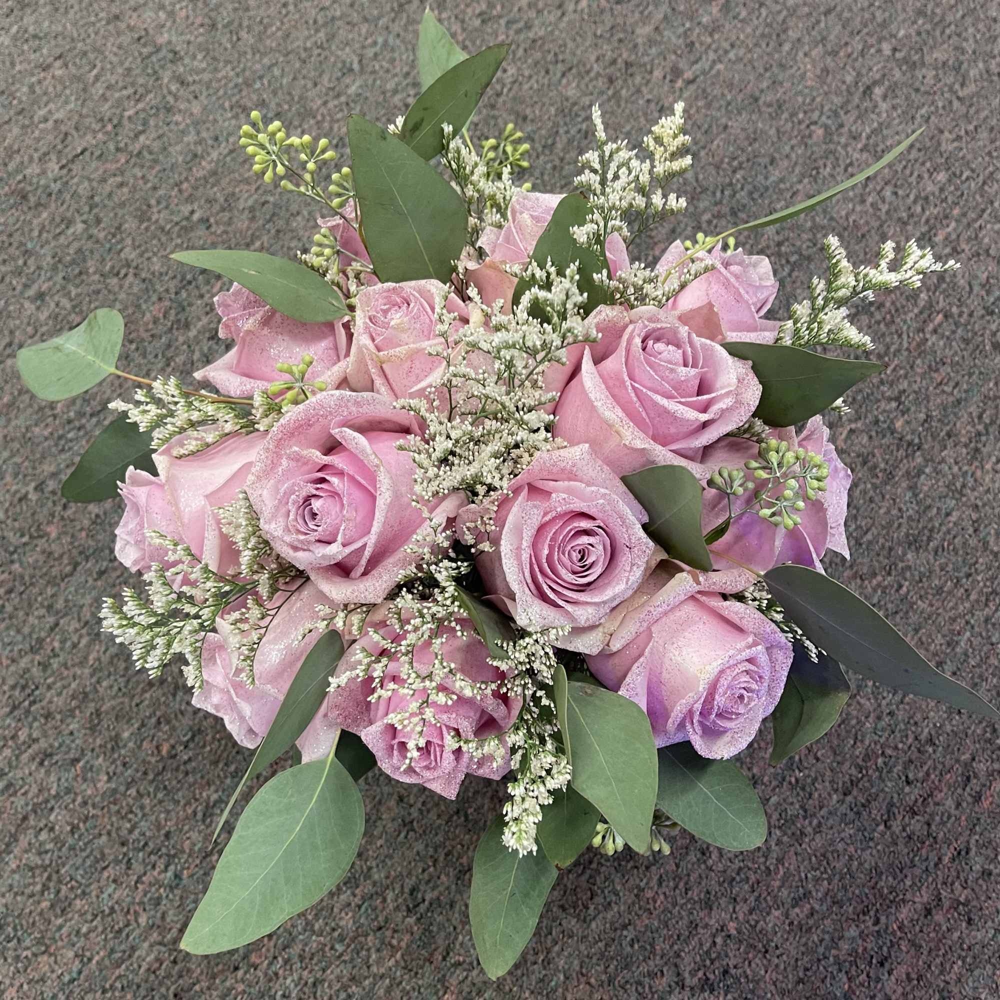 Pink rose bouquet with white filler flowers and green leaves
