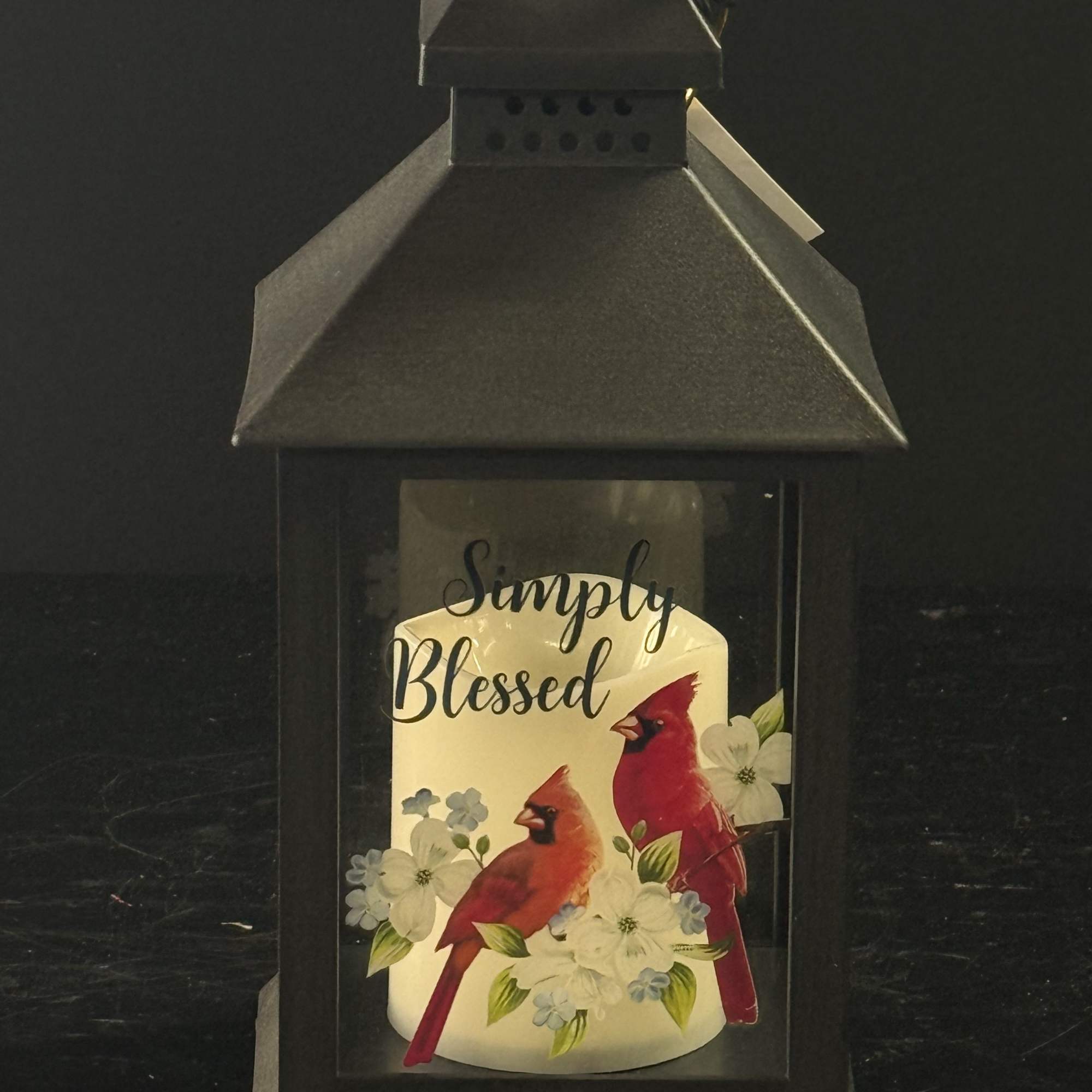 Black lantern with a candle labeled Simply Blessed and cardinals
