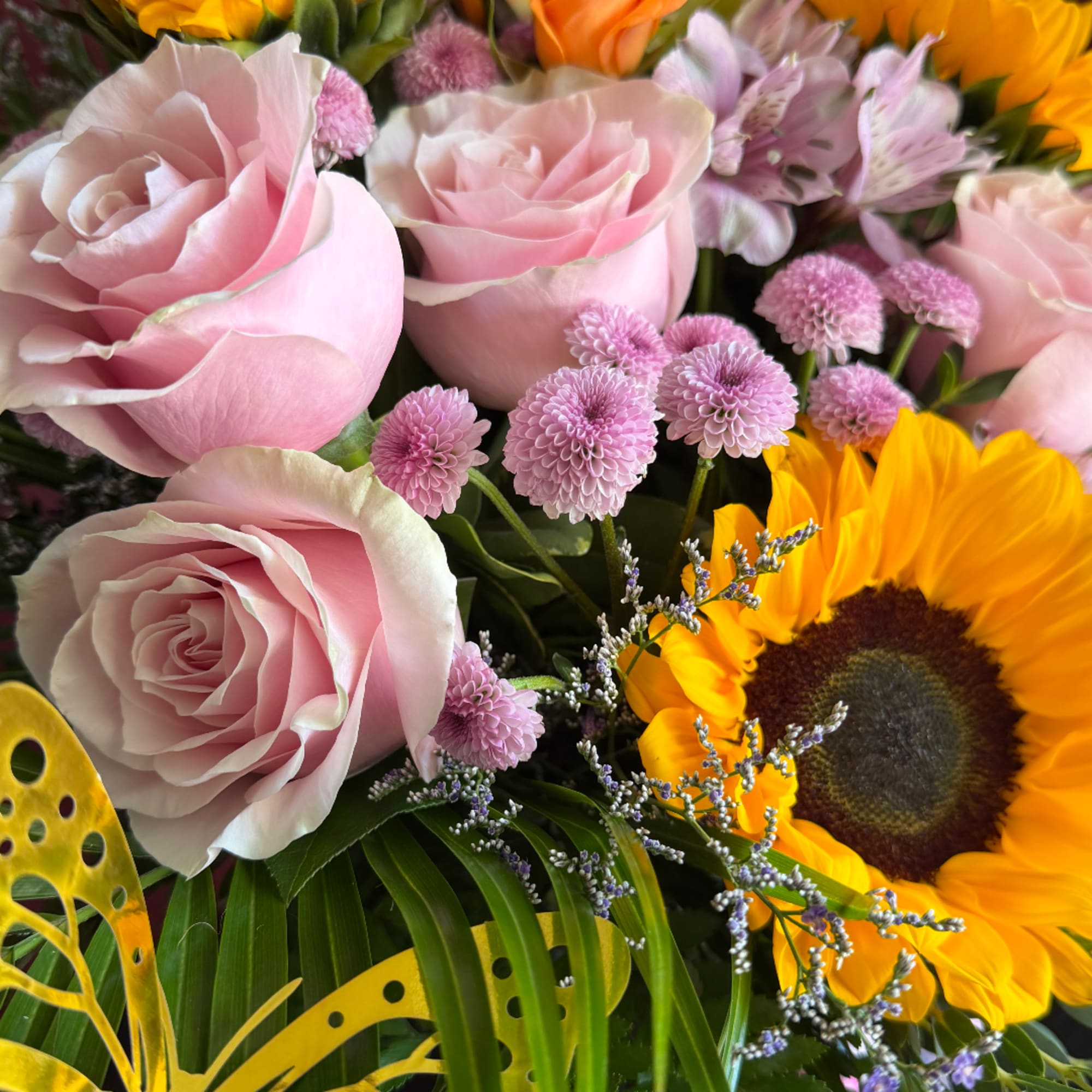 Pink roses and yellow sunflowers in a mixed bouquet